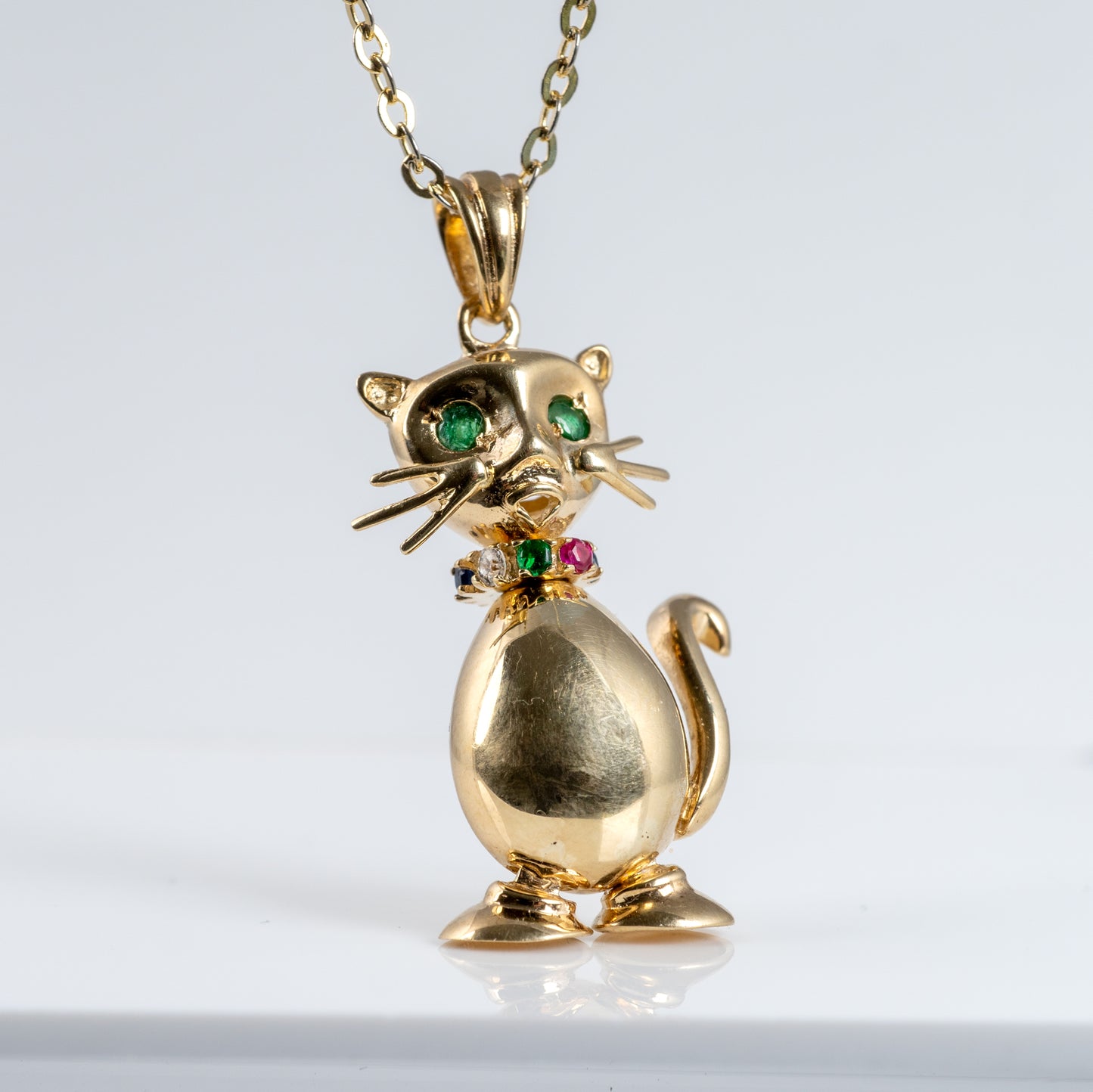 gold cat charm with gemstones