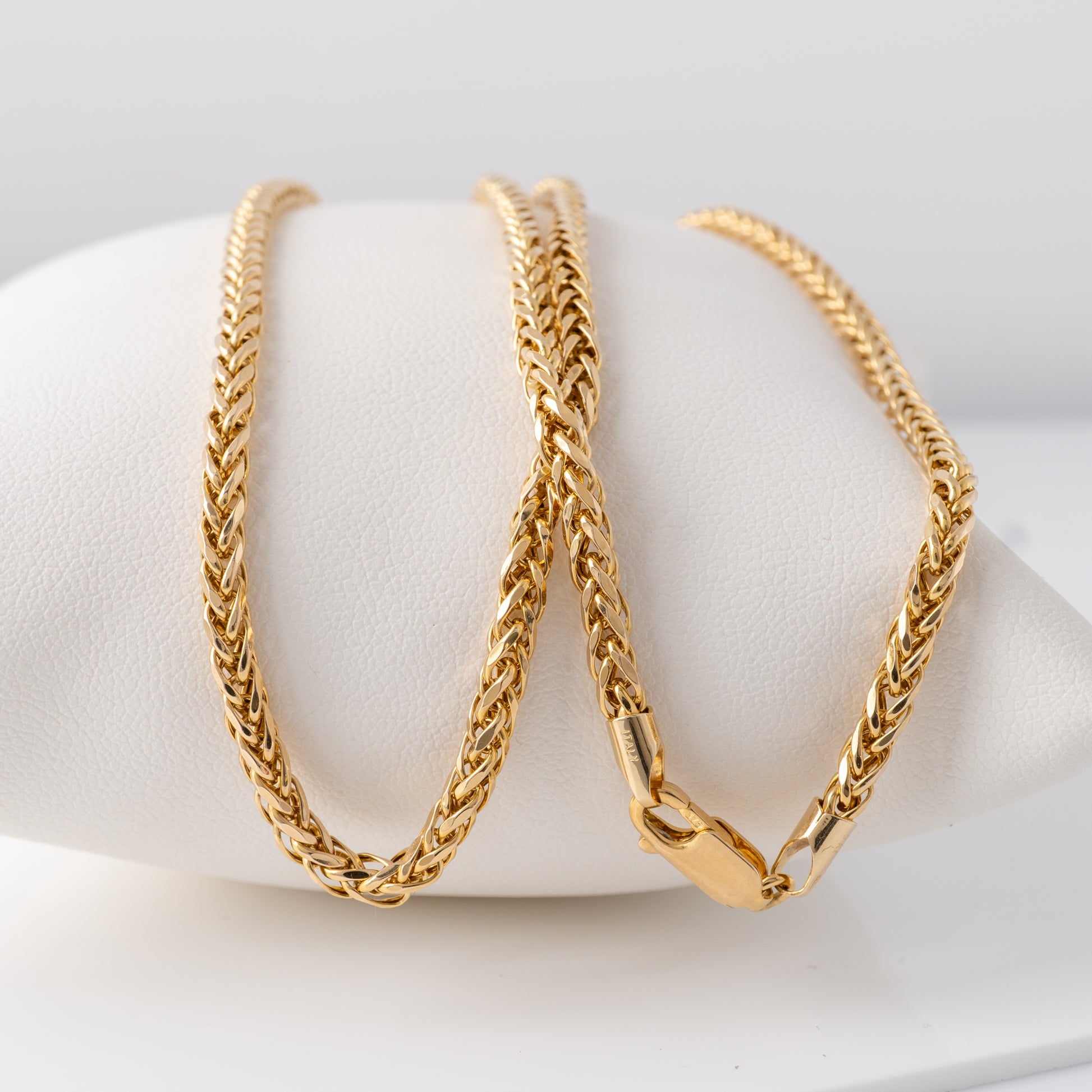 Close-up of the 9ct gold spiga wheat chain necklace, highlighting the clasp and interwoven design