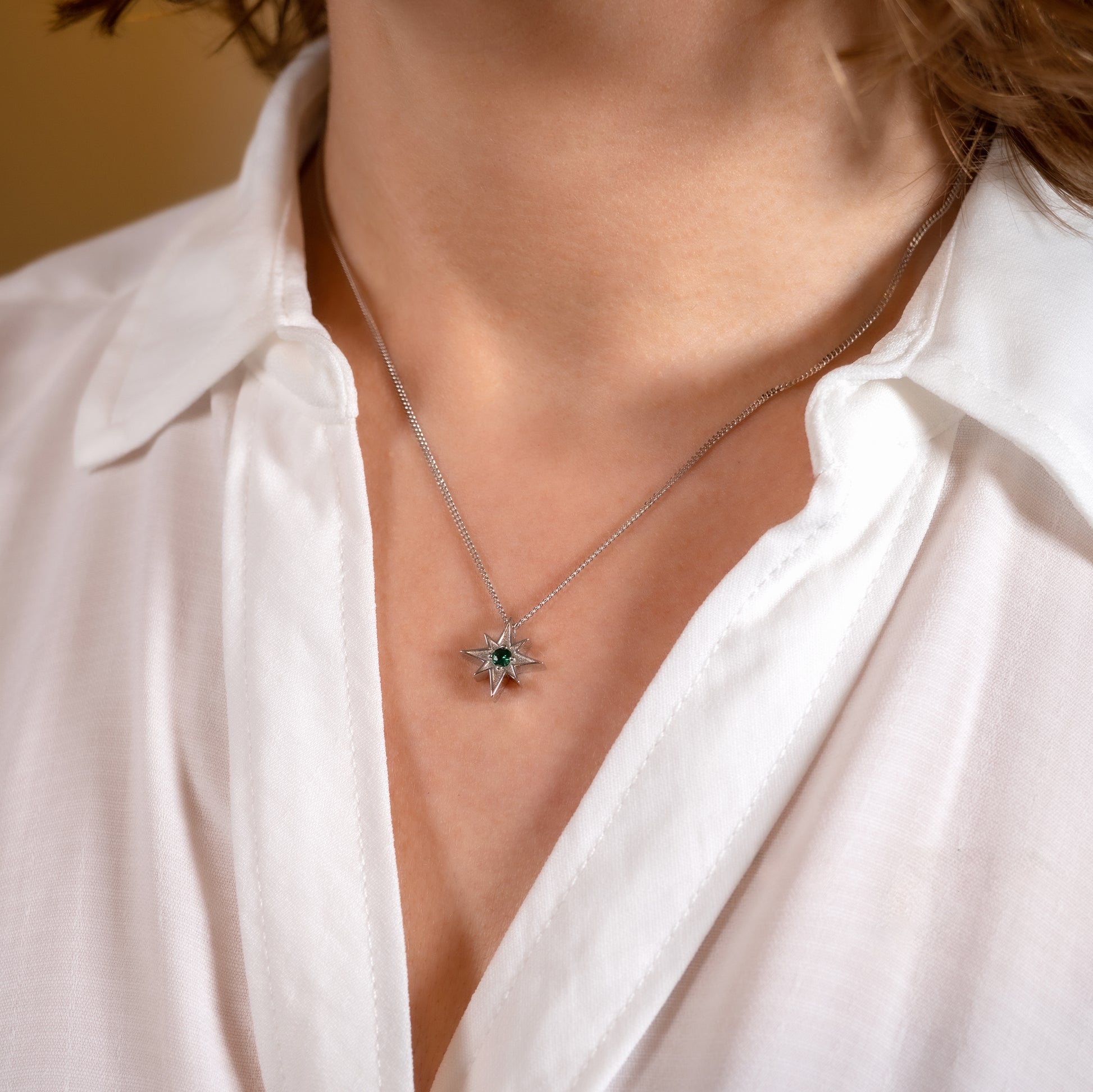 green gemstone north star necklace worn on model