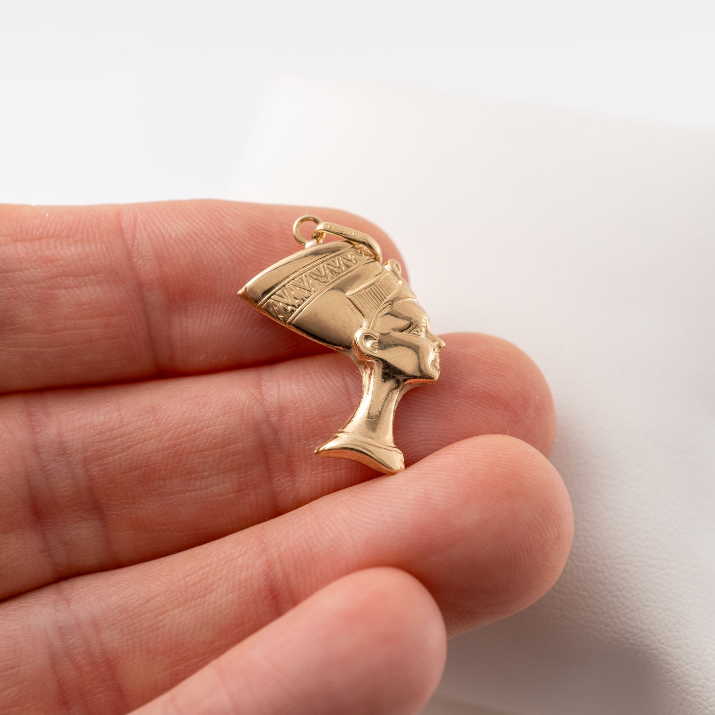 9ct gold Nefertiti pendant held in hand to showcase its size and intricate design