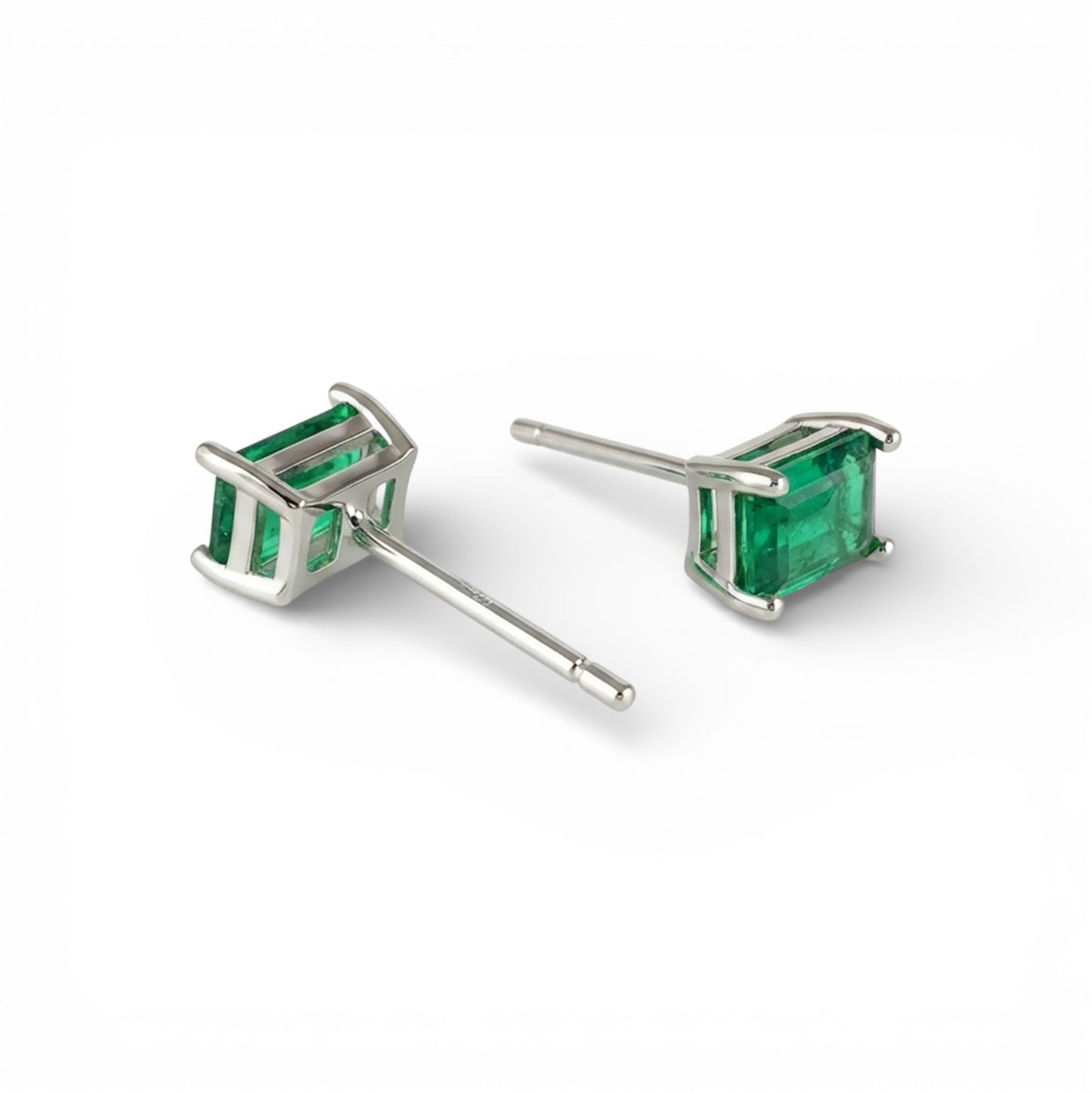 Pair of emerald green square-cut gemstone stud earrings on a white background