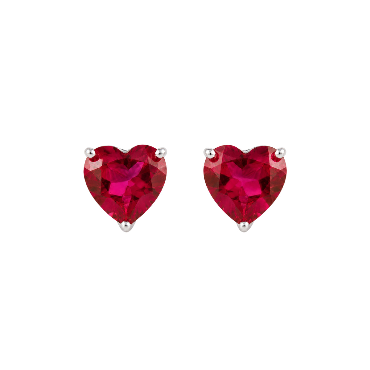 A pair of heart-shaped stud earrings featuring vibrant lab ruby heart-cut gemstones in silver prong settings, shown against a plain white background.