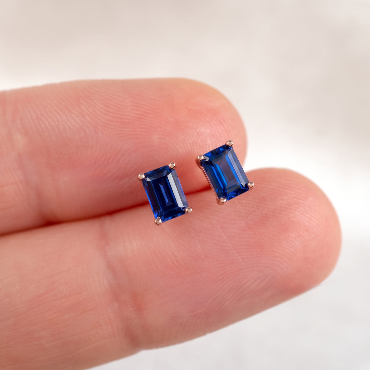 6 x 4mm lab sapphire rectangle stud earrings shown on the hand