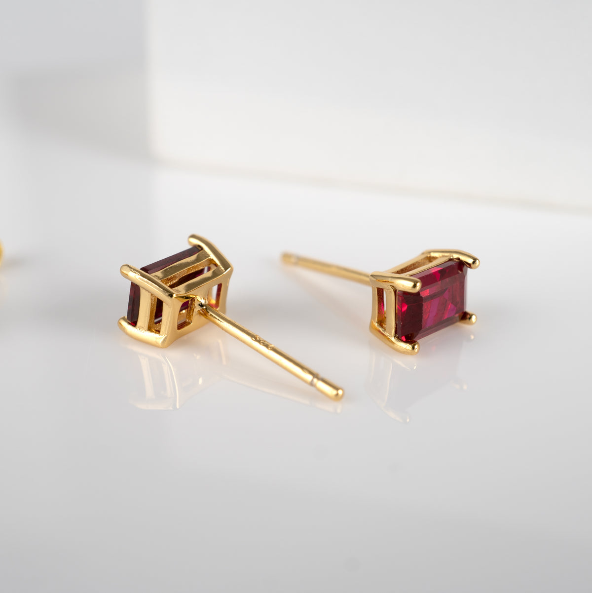 lab grown ruby studs pair in yellow gold showing front and back 