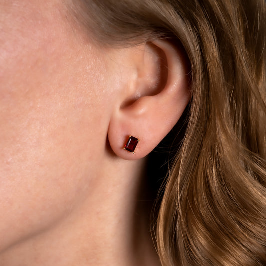 woman wearing lab ruby stud earring to show the size and shape
