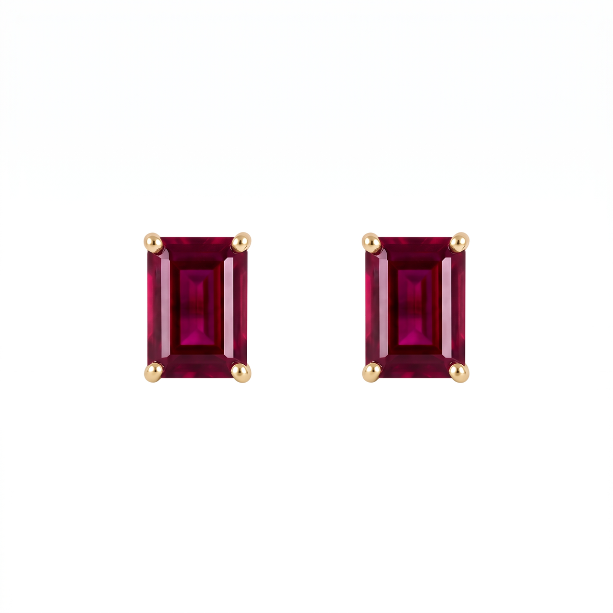 A pair of rectangular emerald-cut lab ruby stud earrings in yellow gold prong settings, shown on a plain white background.