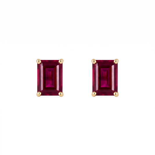 A pair of rectangular emerald-cut lab ruby stud earrings in yellow gold prong settings, shown on a plain white background.