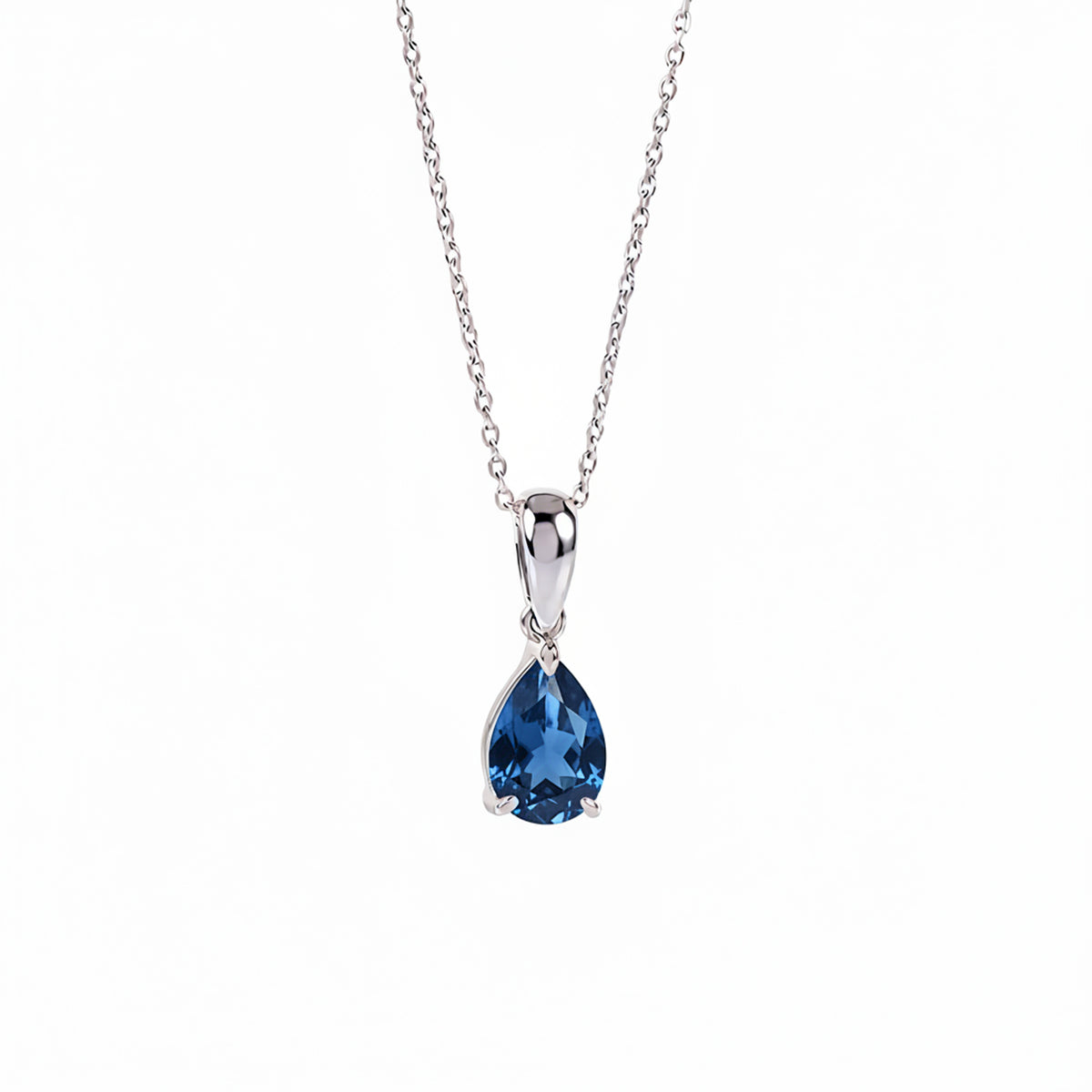 A silver pendant necklace featuring a teardrop-shaped london blue topaz gemstone in a polished silver setting, suspended from a delicate silver chain against a plain white background.