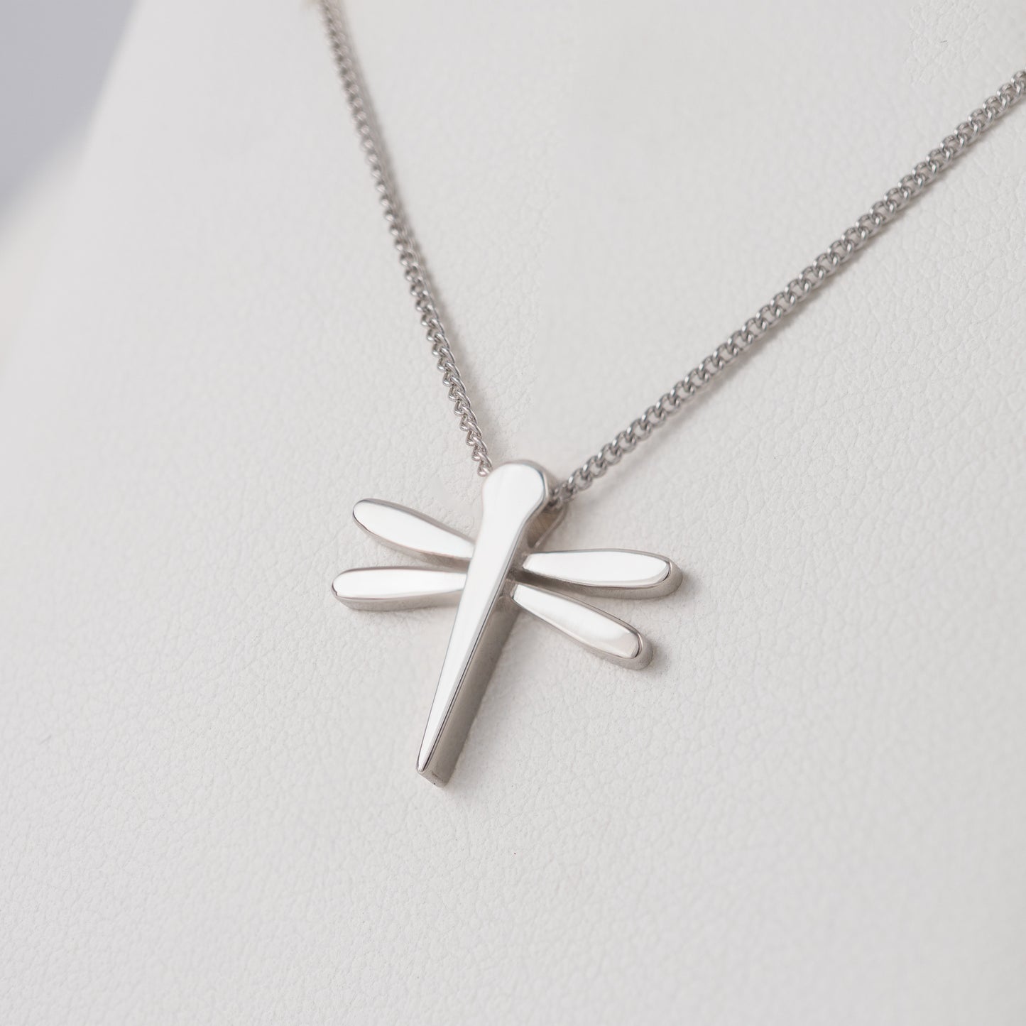Silver dragonfly pendant necklace slight angled view on a light background