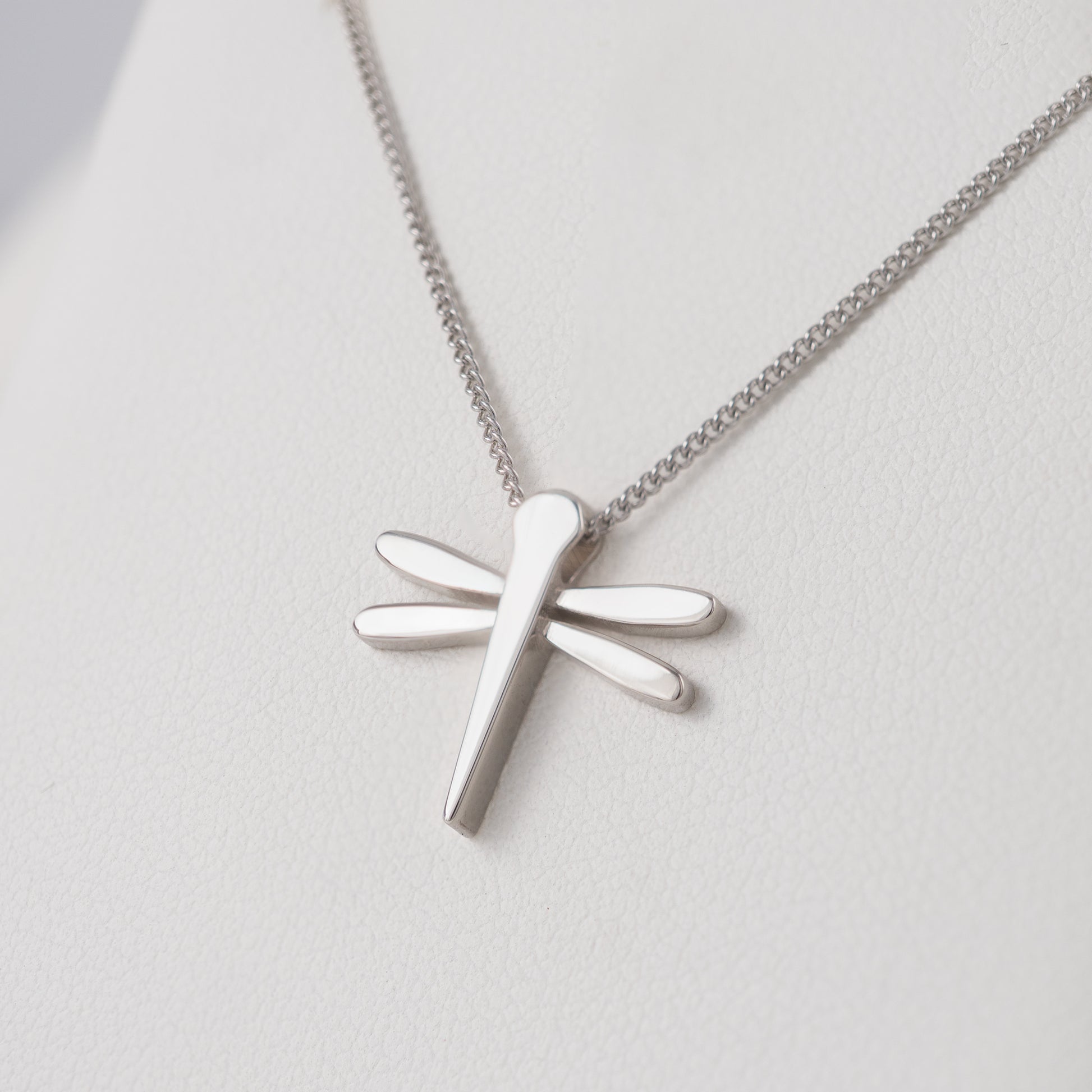 Silver dragonfly pendant necklace slight angled view on a light background