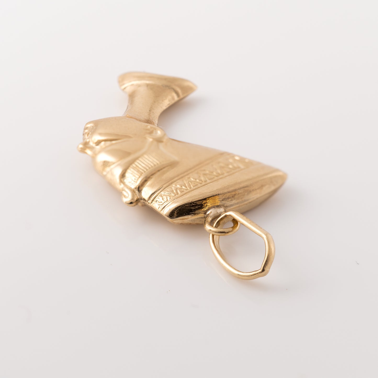 Back angle of a gold Nefertiti pendant highlighting the bail attachment and intricate craftsmanship