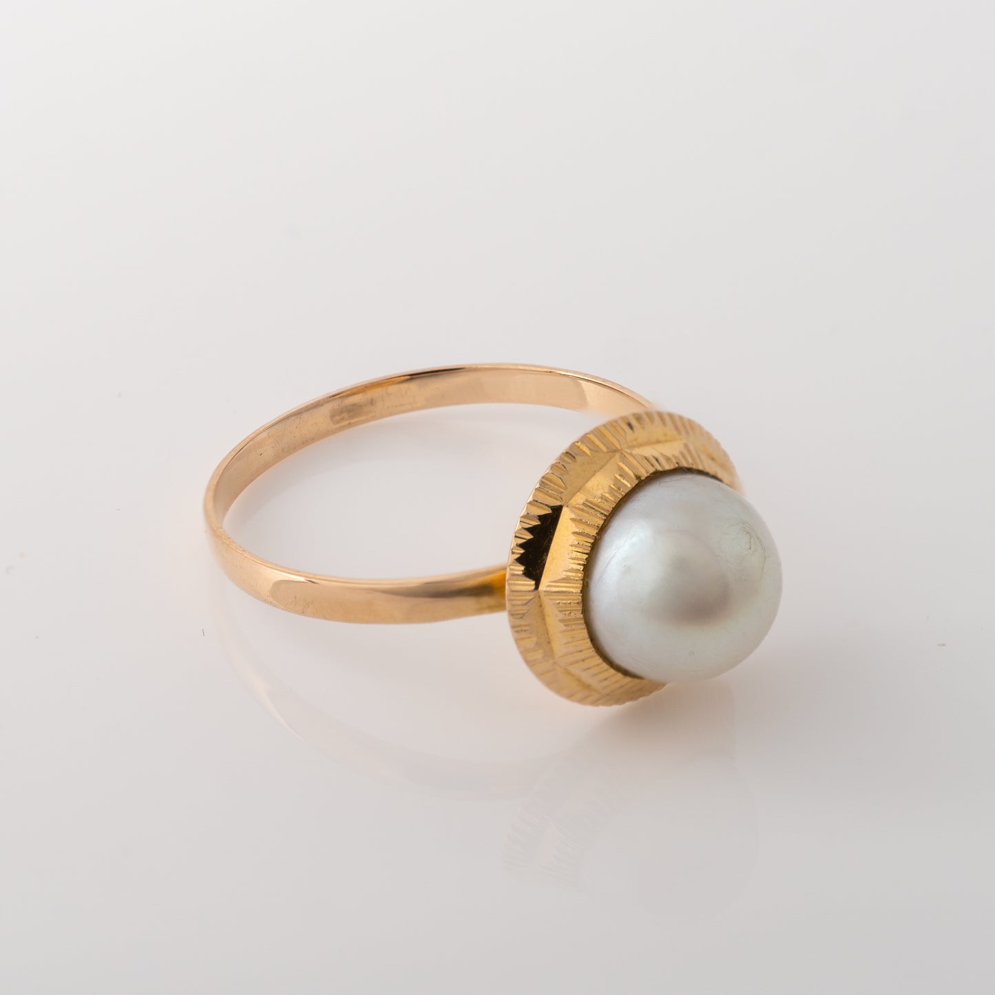 Angled view highlighting the pearl and engraved detail on vintage ring