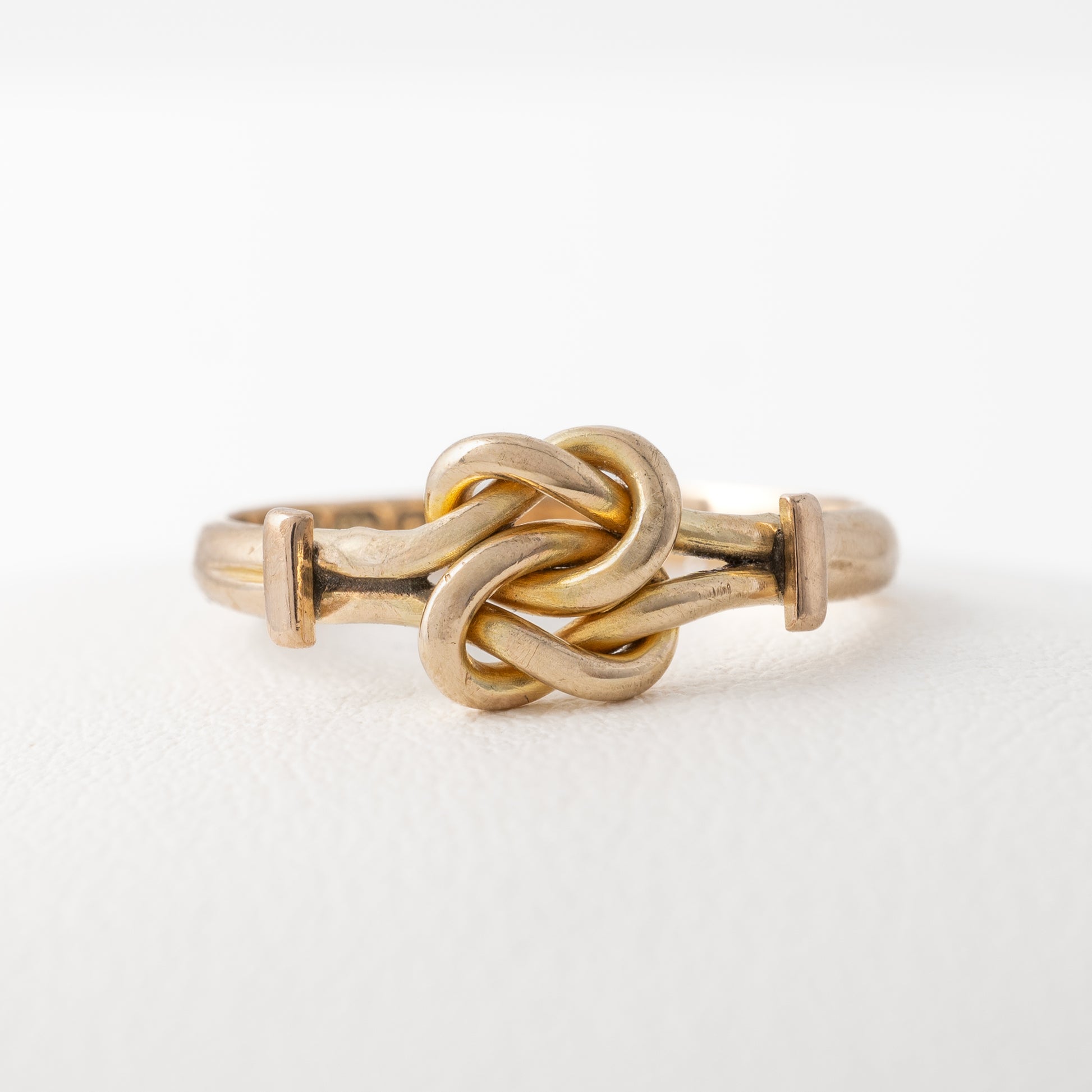 Front view of plain gold knot ring, highlighting the knot design and gold band