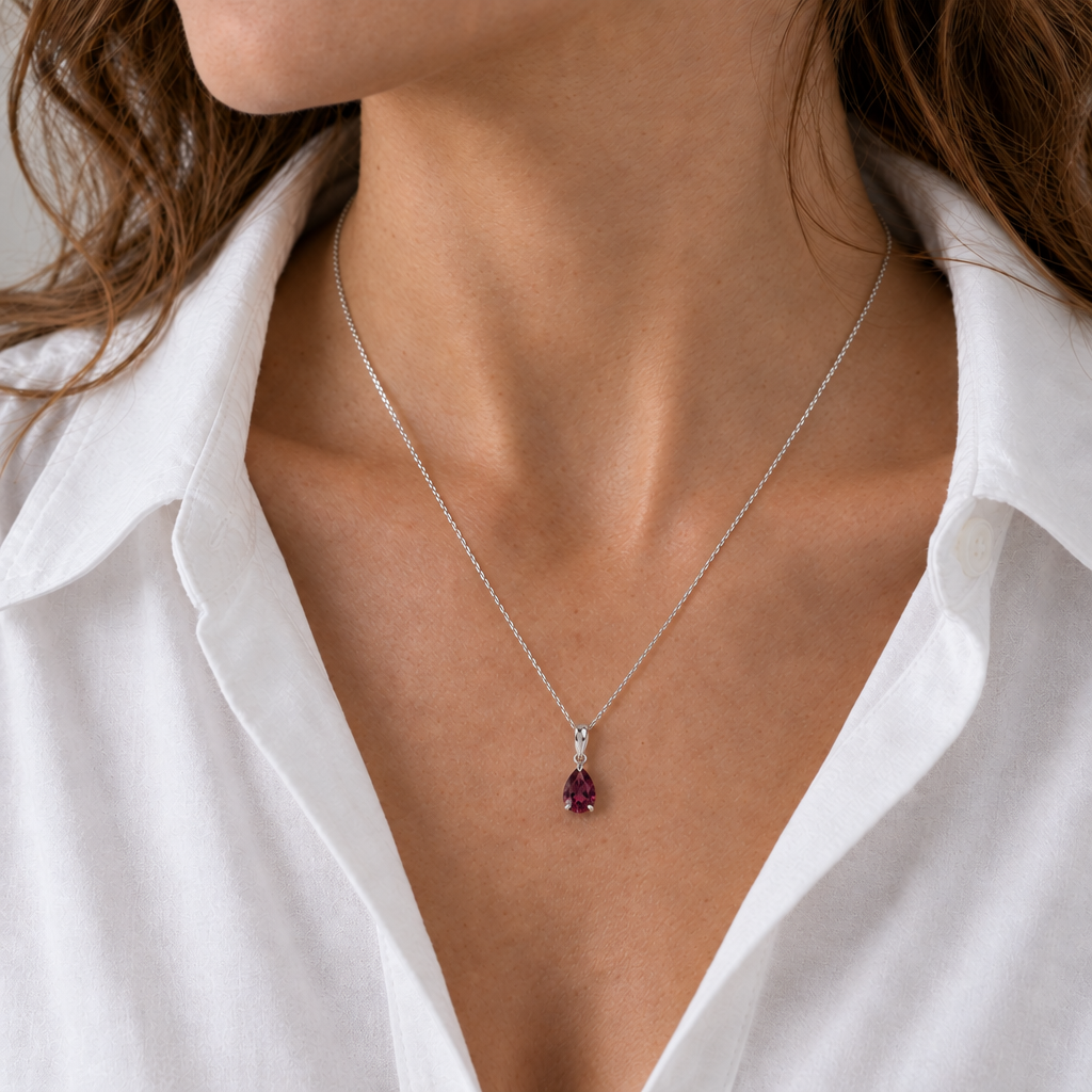 Rhodolite garnet teardrop necklace on a silver chain worn with an open-neck white shirt, AI visualisation.