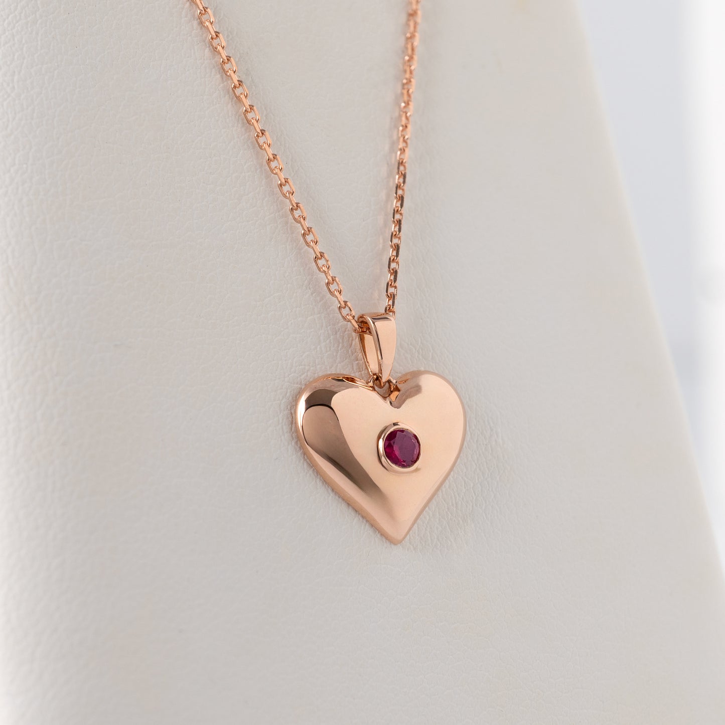 Lab ruby heart necklace in 375 rose gold shown hanging freely to show scale and proportions