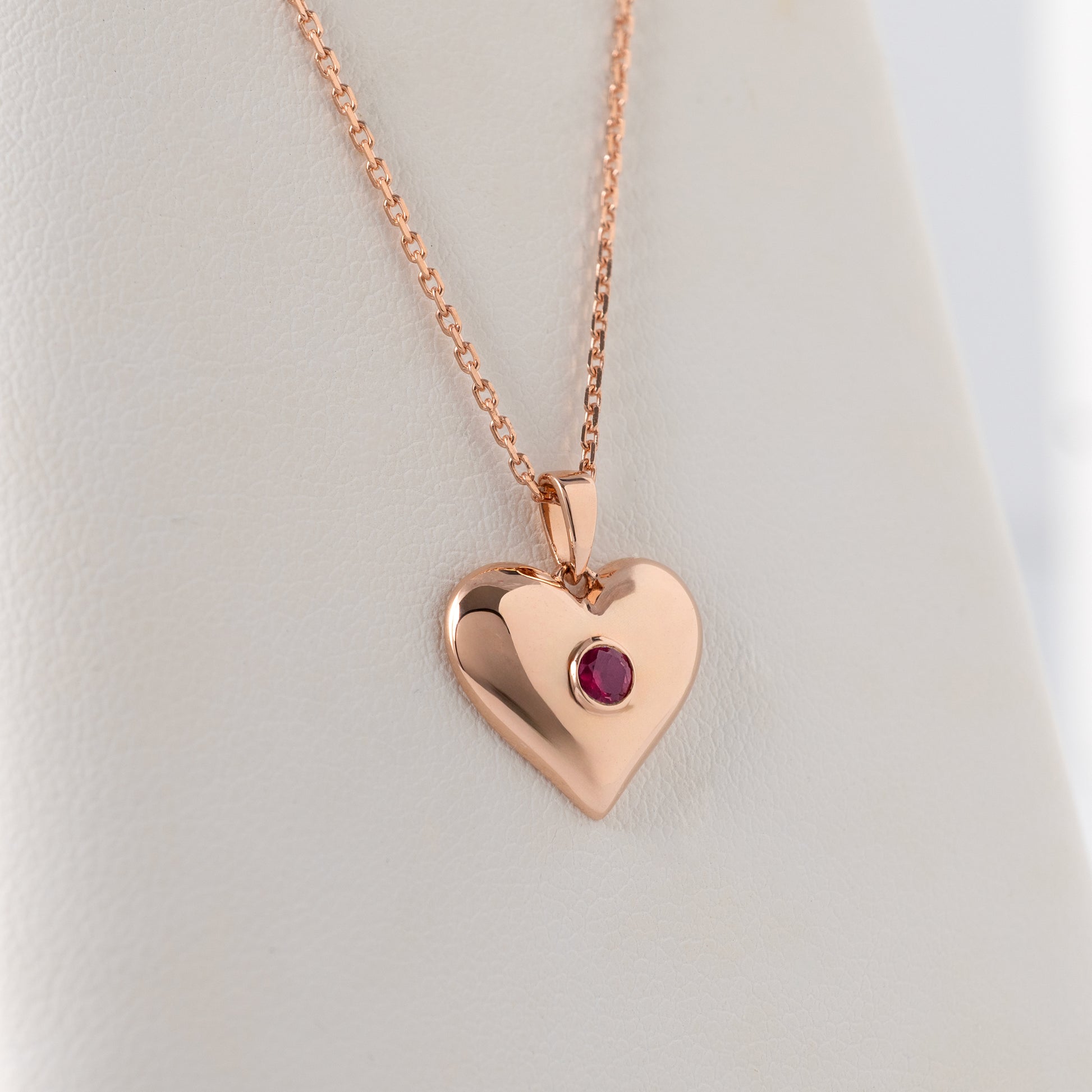 Lab ruby heart necklace in 375 rose gold shown hanging freely to show scale and proportions