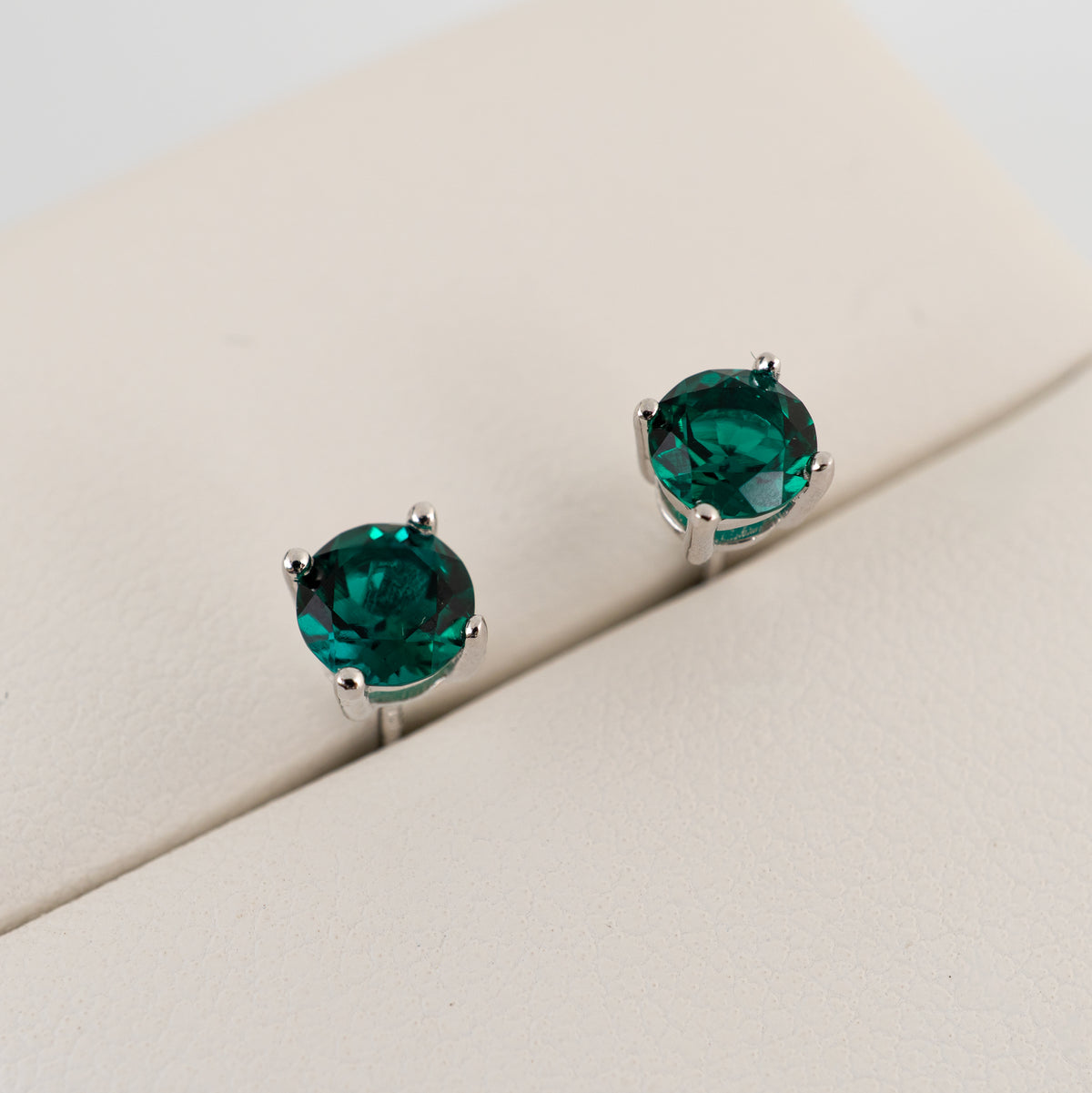 Round lab emerald stud earrings with deep Zambian-style green colour in sterling silver