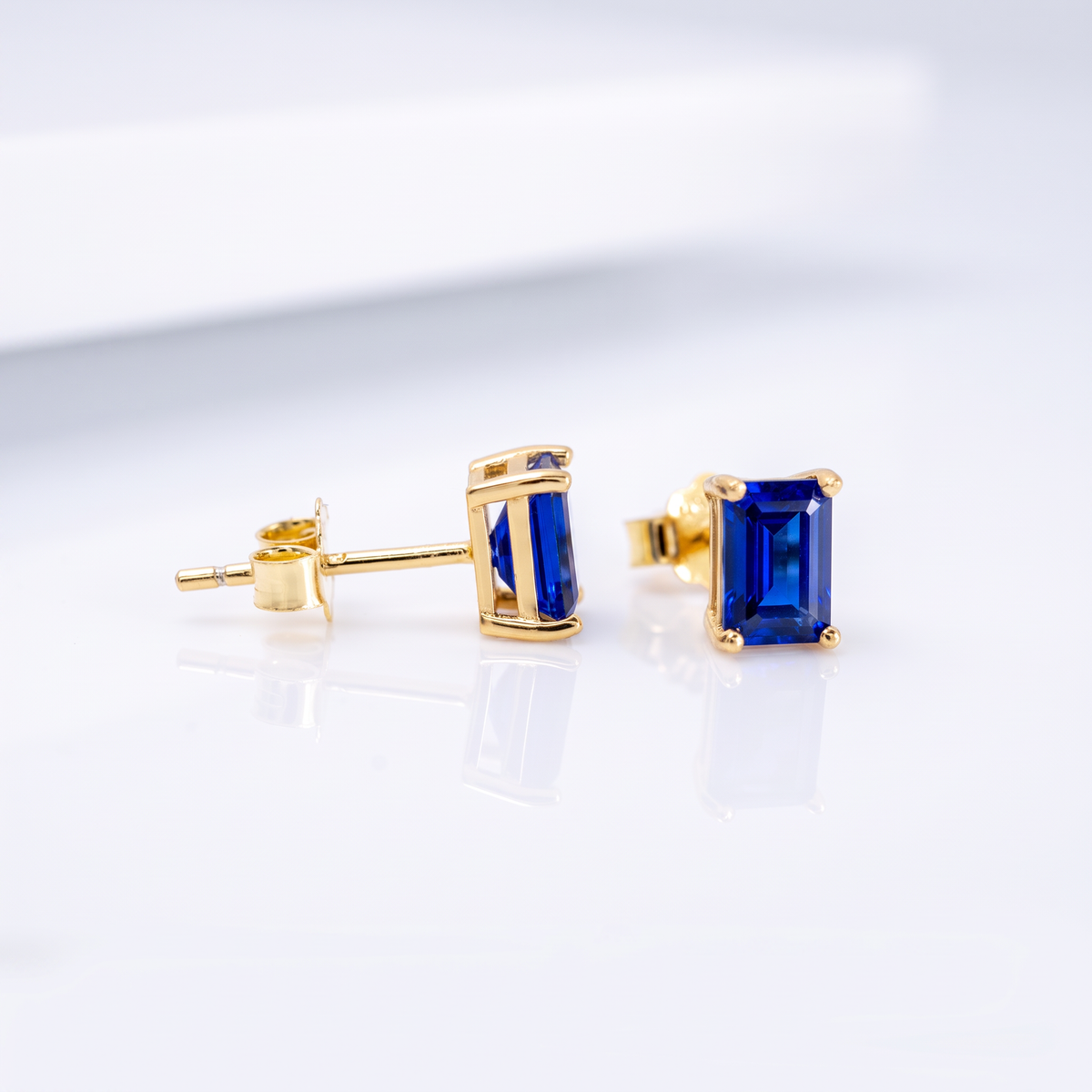 Royal blue rectangle sapphire stud earrings in yellow gold-plated silver