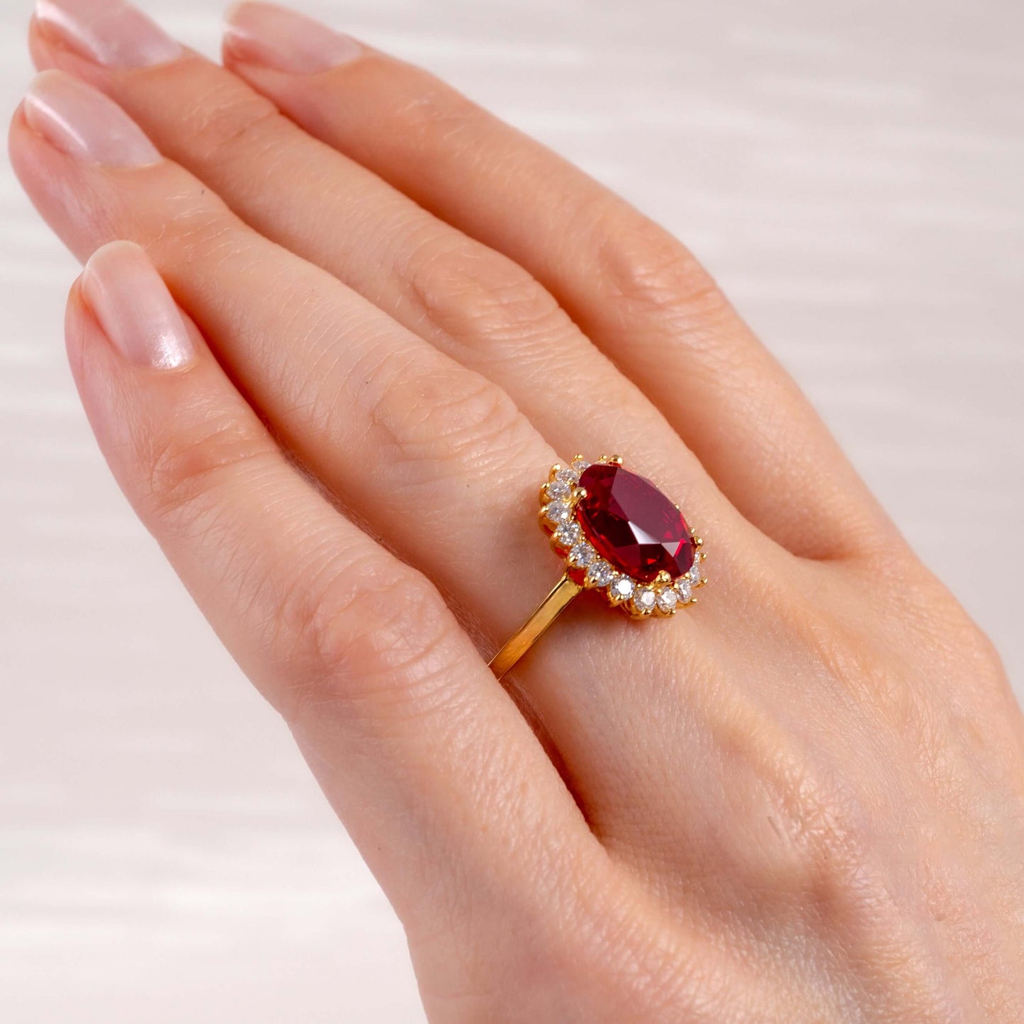 Elegant ruby gold ring with moissanite halo on woman's hand