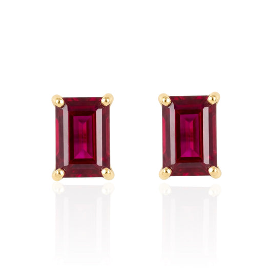 Pair of emerald-cut lab ruby earrings with gold settings on a white background