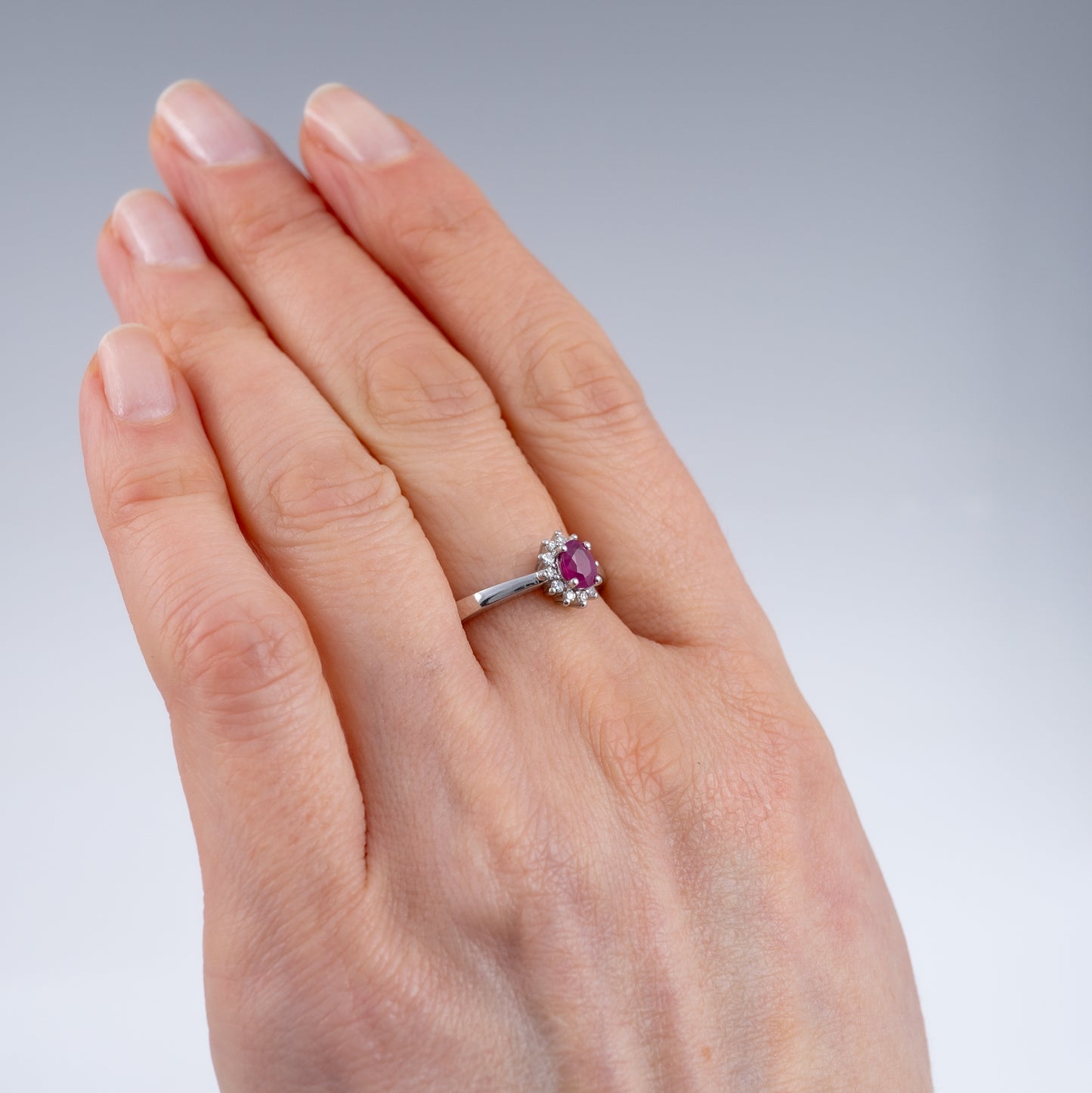 ruby diamond halo ring womans hand side angle