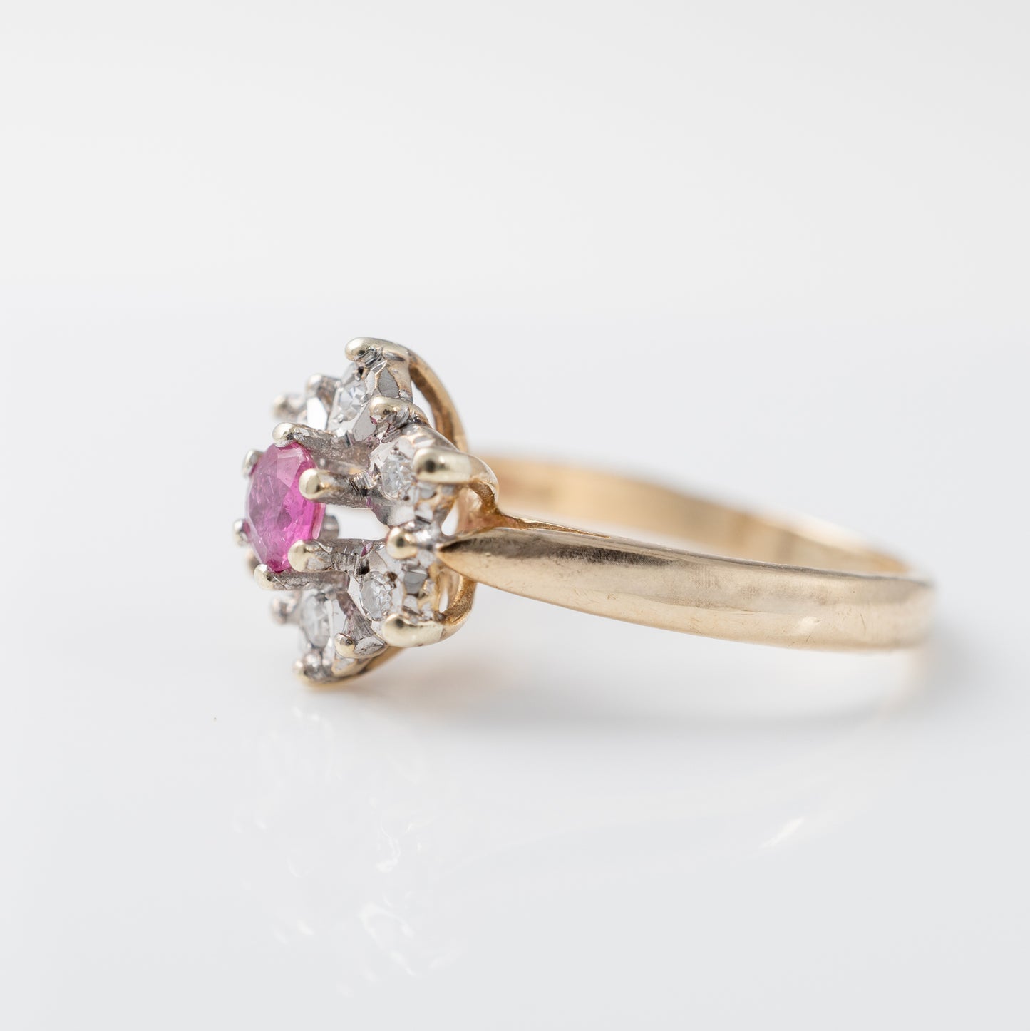 Side view of ruby engagement ring with diamond halo in 9ct yellow gold