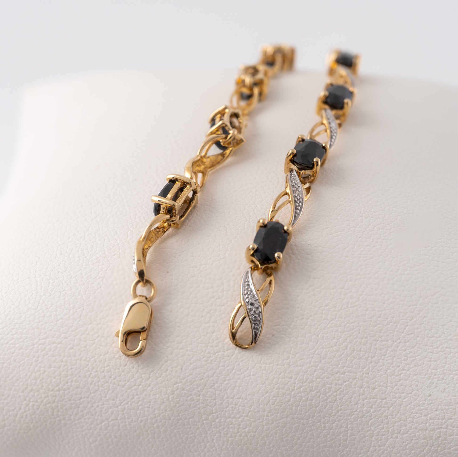 Close-up of the 9ct gold blue sapphire bracelet showing the clasp and gemstone details.