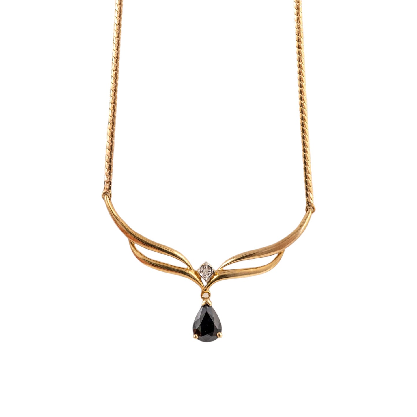 A gold necklace with a twisted chain, a curved wing-like pendant, a small clear accent stone, and a teardrop-shaped dark  blue gemstone at the center, shown on a plain white background.
