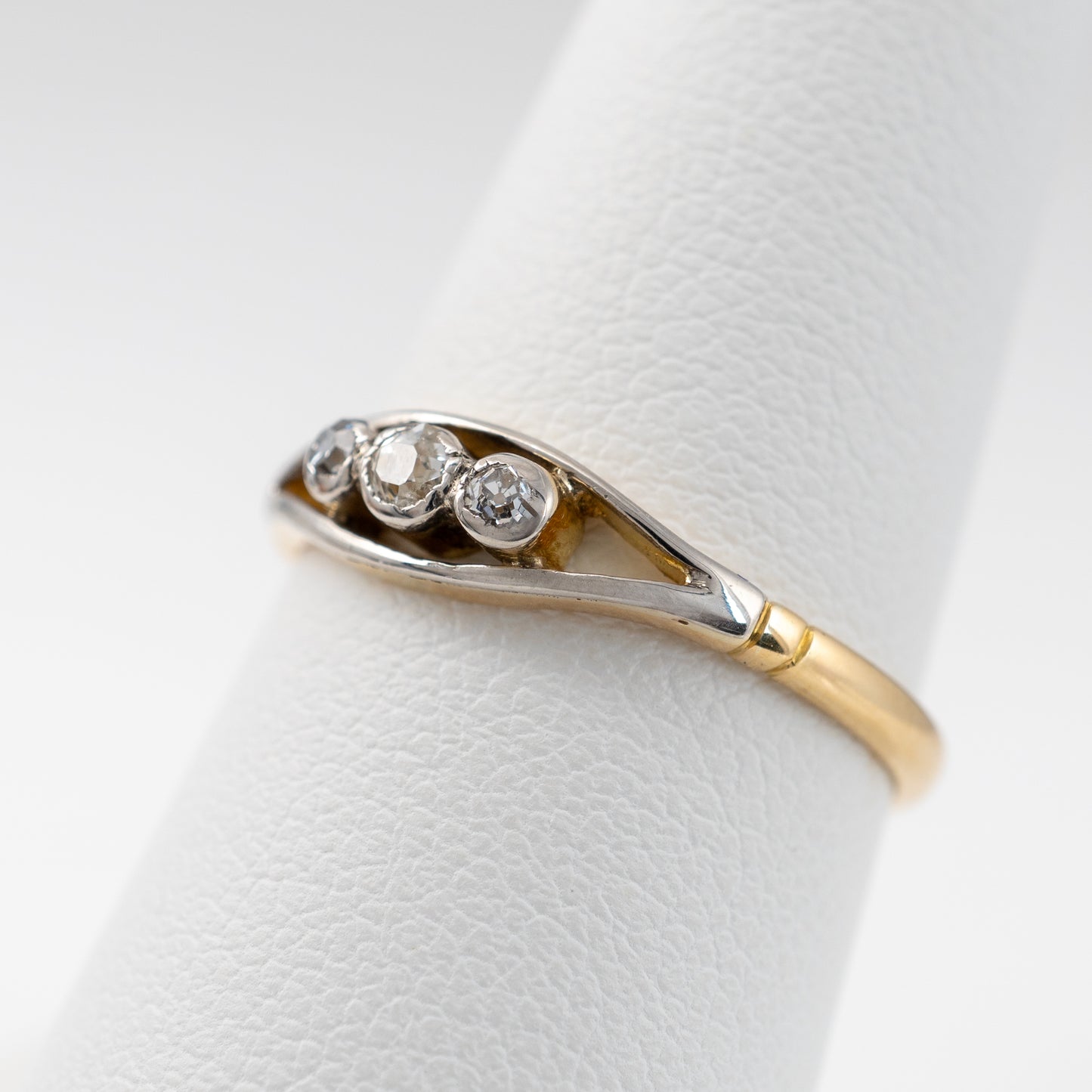 Side profile of vintage three-stone diamond ring in 18ct gold, showing old-cut diamonds