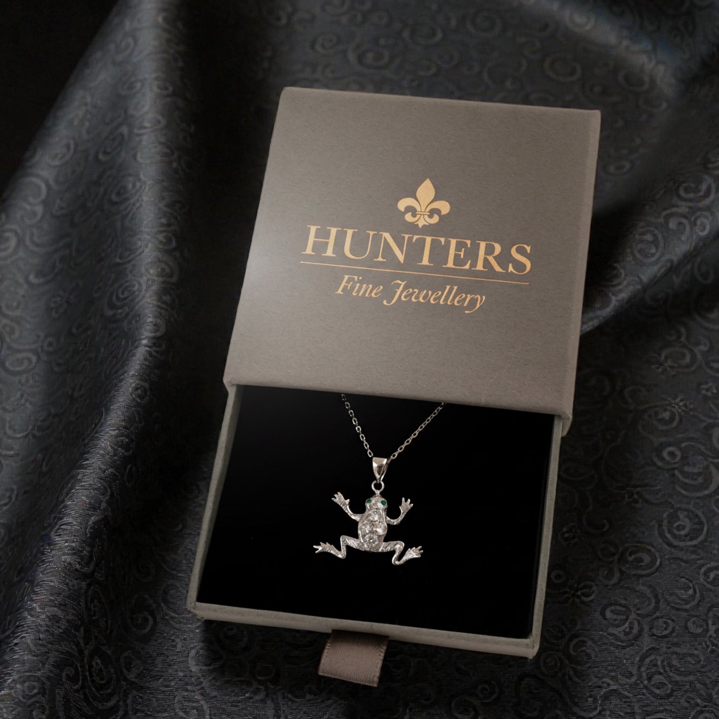 Jewelry box with a silver pendant inside, featuring the 'Hunters Fine Jewellery' brand.