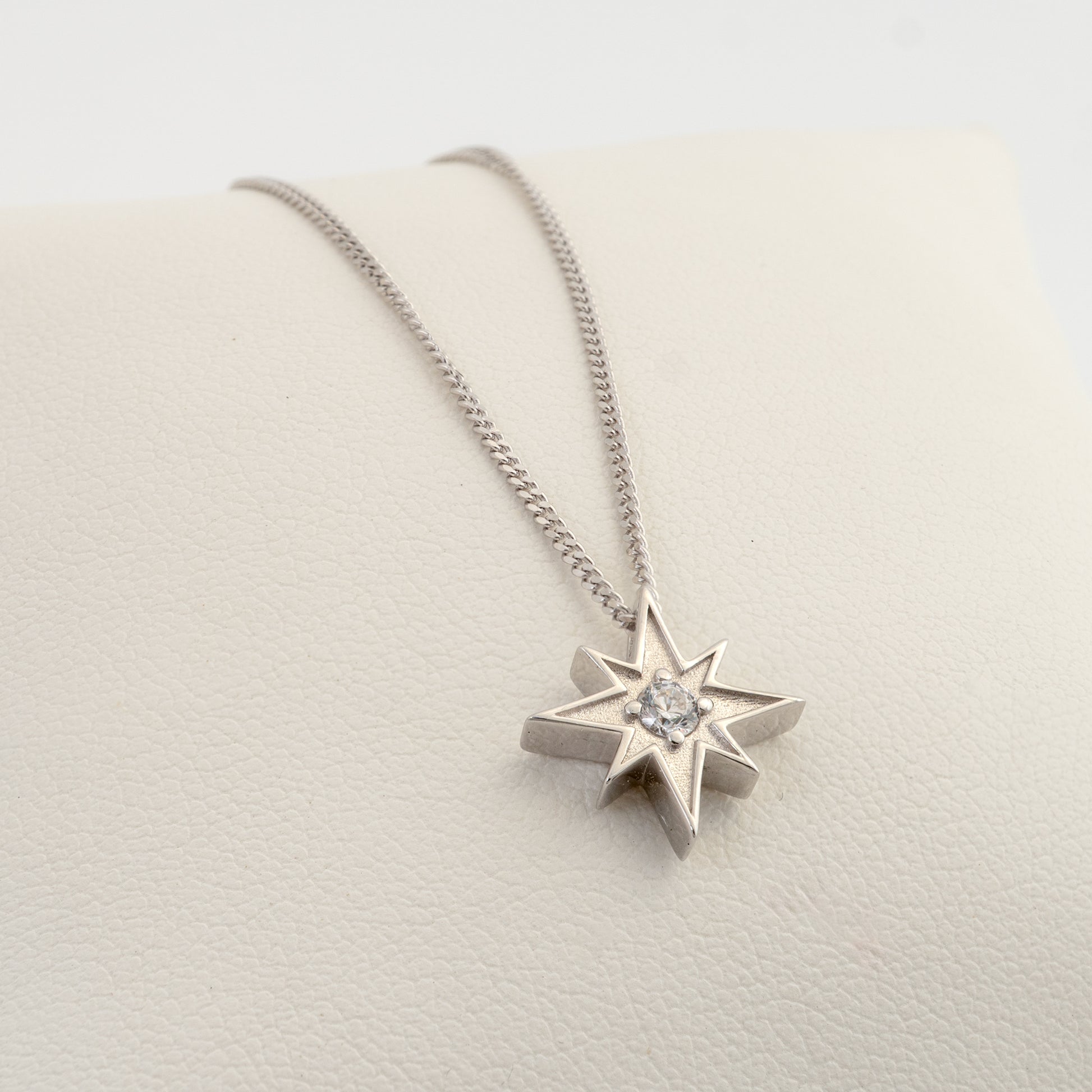 Angled view of silver North Star necklace with clear stone pendant