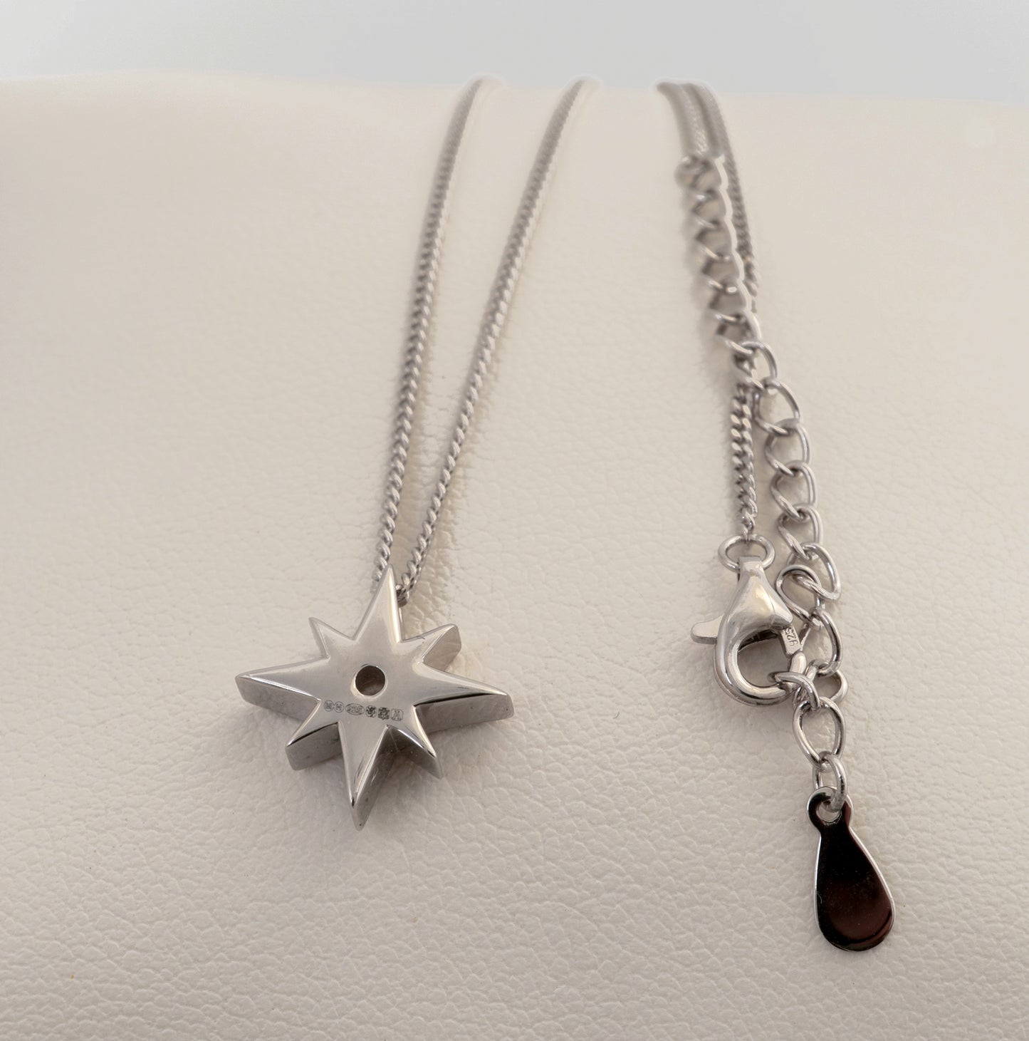 Silver north star pendant necklace with a chain and hallmarks visible