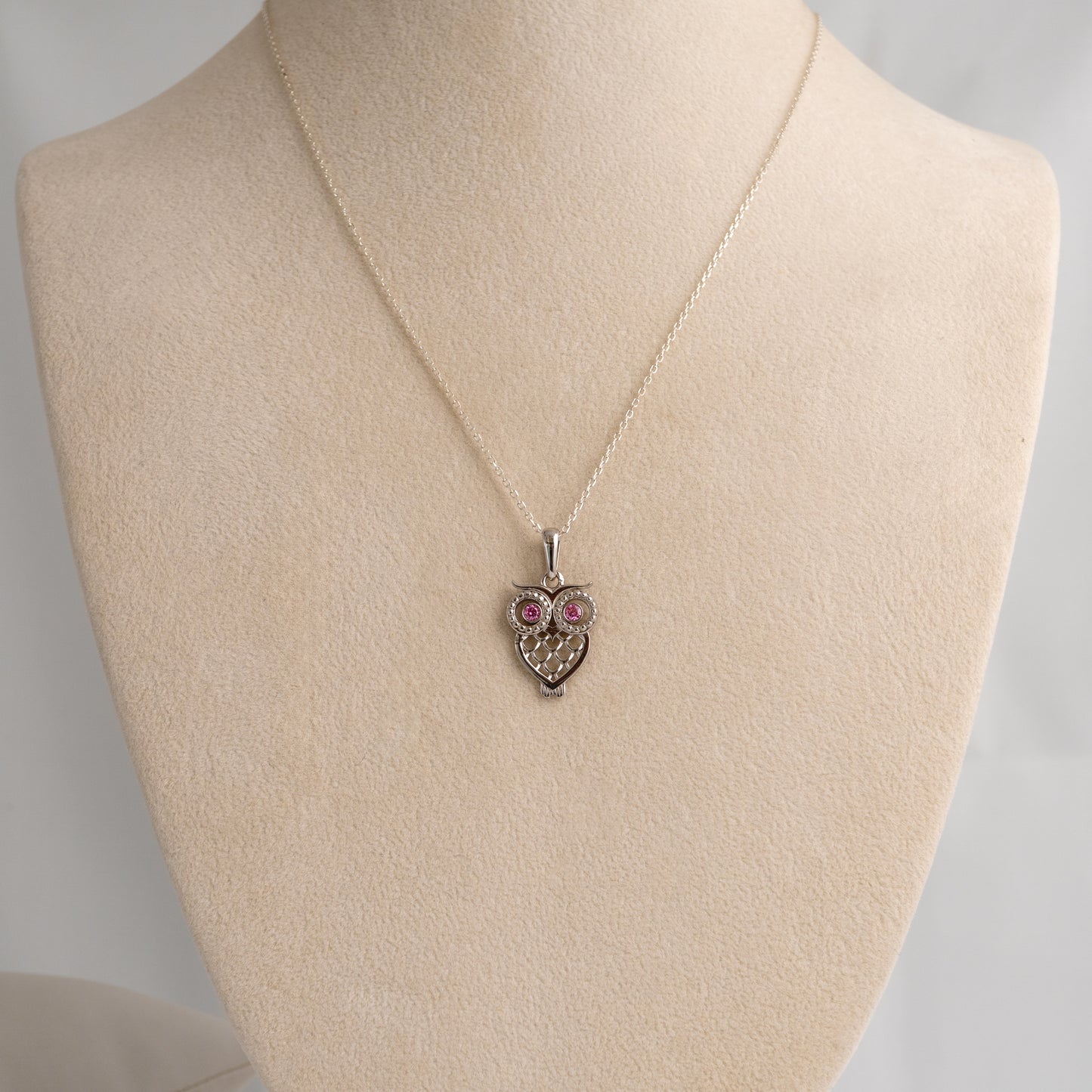 silver owl pendant necklace pendant necklace on a mannequin bust with a plain background