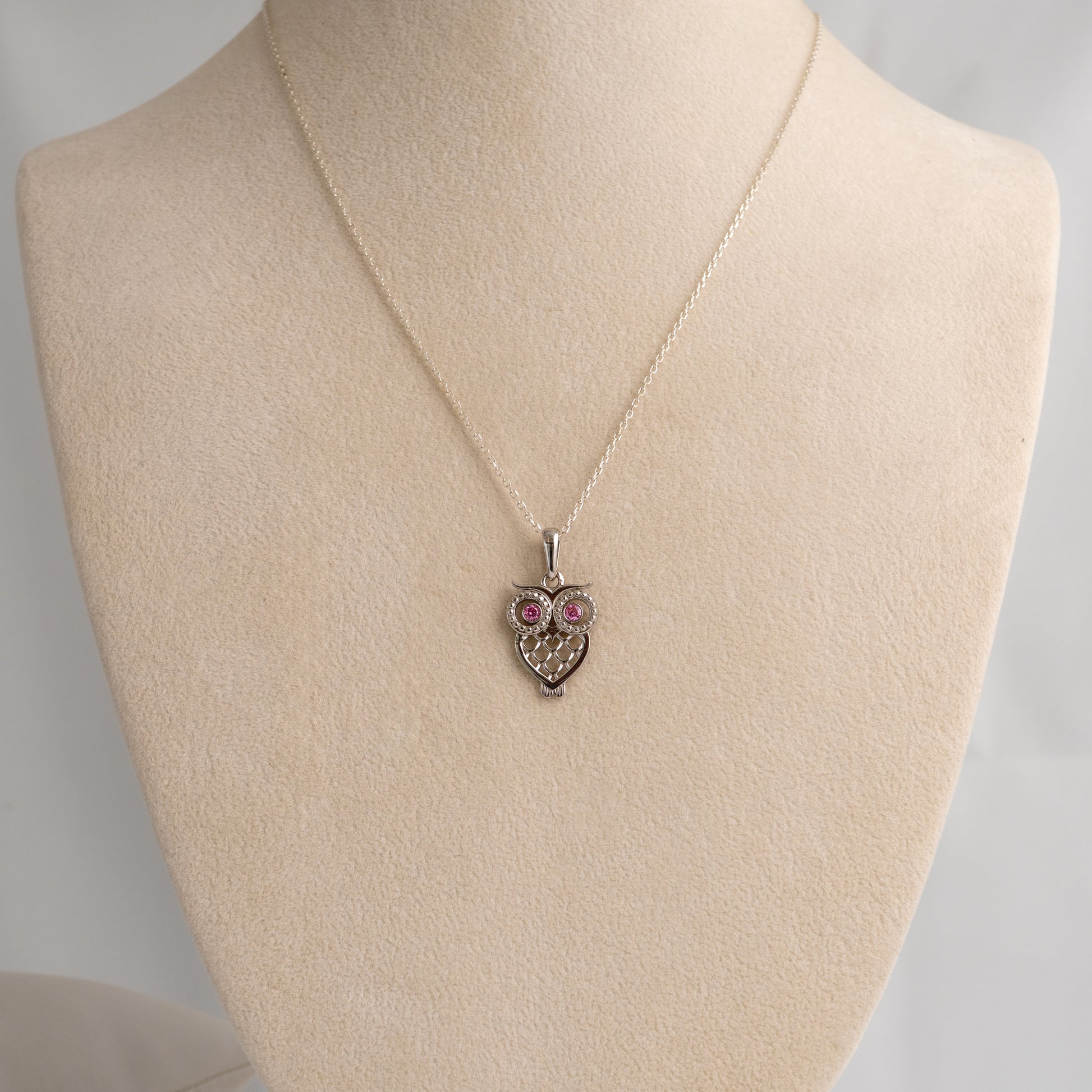 silver owl pendant necklace pendant necklace on a mannequin bust with a plain background