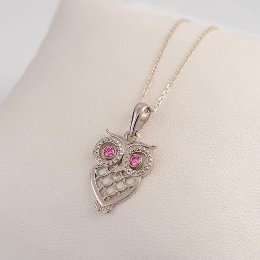 Silver owl pendant with pink gemstones on a white background