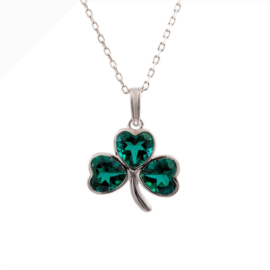 A sterling silver shamrock pendant necklace with three heart-shaped emerald green crystals, shown on a white background.