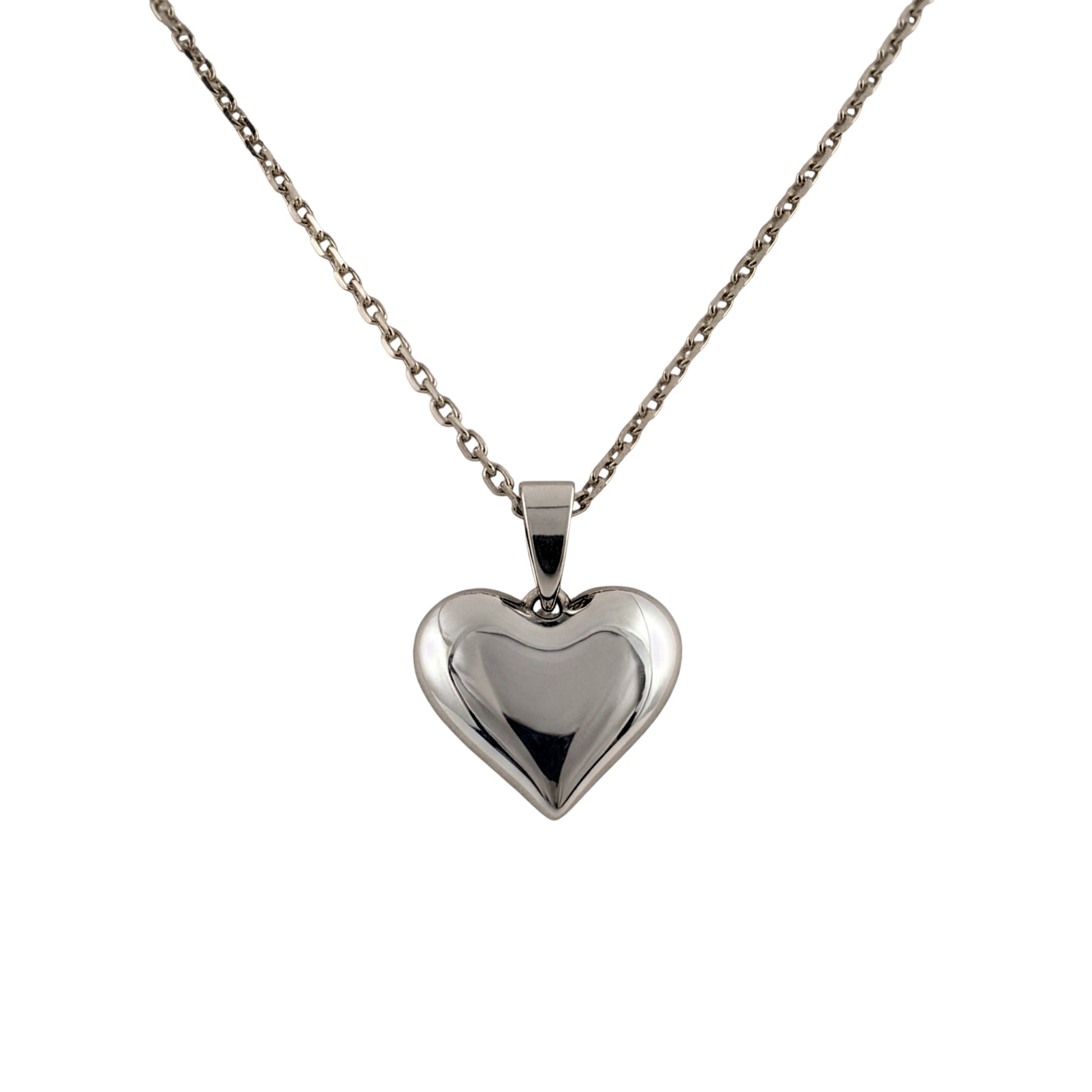 A polished silver heart-shaped pendant necklace on a delicate silver chain, shown against a plain white background.