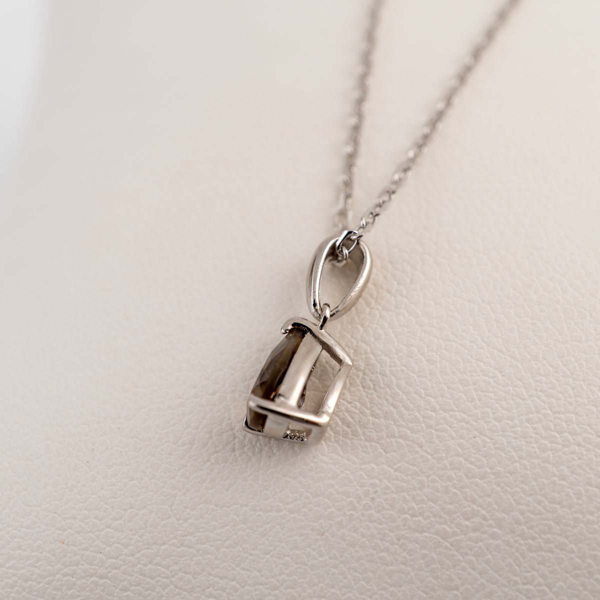 Side view of the smoky quartz pendant showing the sterling silver mount and the bail inside the setting.