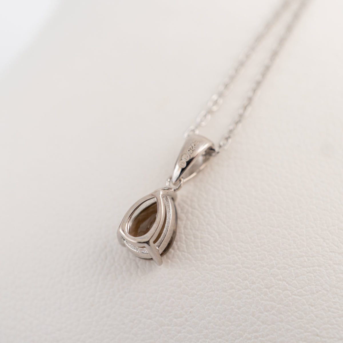 Reverse view of the smoky quartz pear-cut pendant showing the sterling silver mount, 925 stamp and maker’s mark.