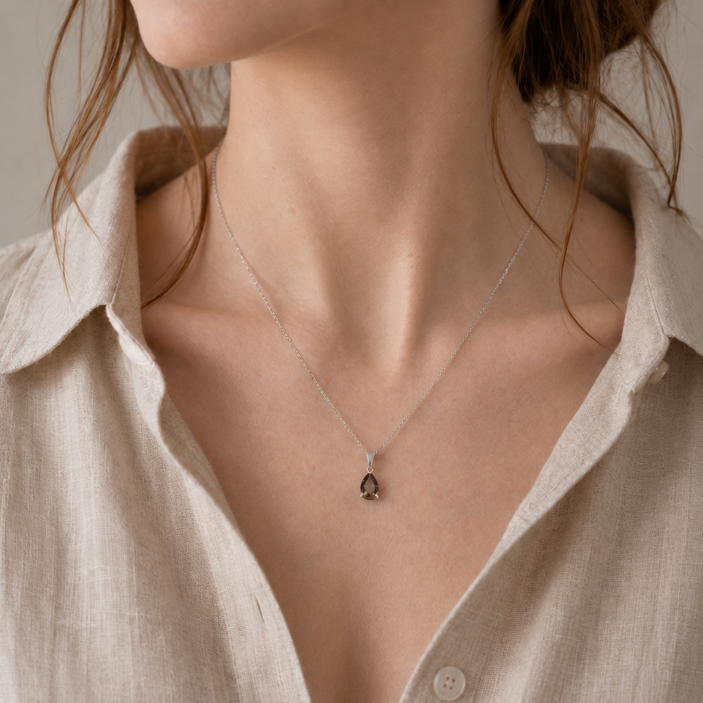 Smoky quartz teardrop pendant necklace worn by a female model with an open white shirt, showing the pendant’s scale.