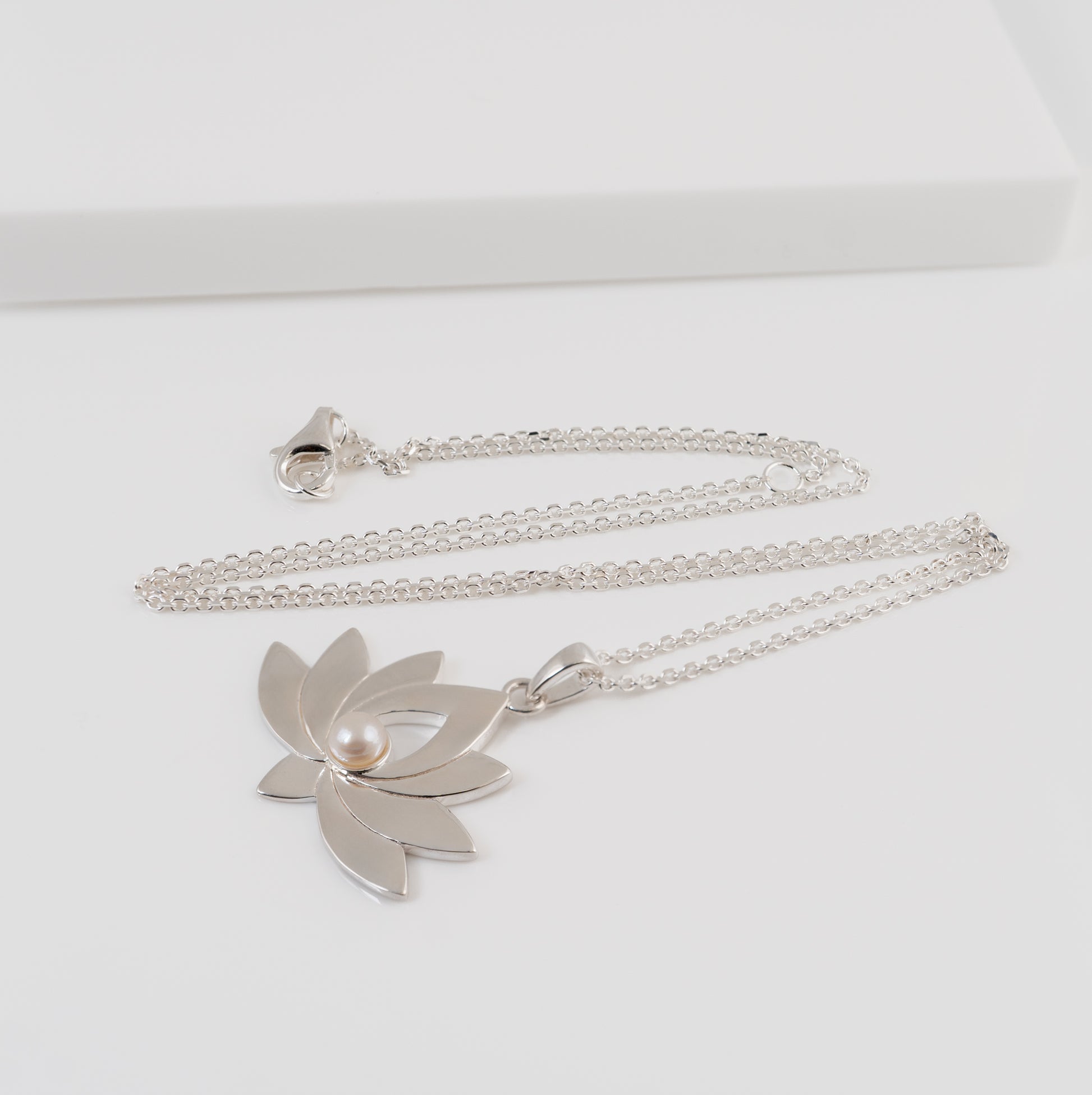 Silver necklace with a lotus flower necklace on a white background