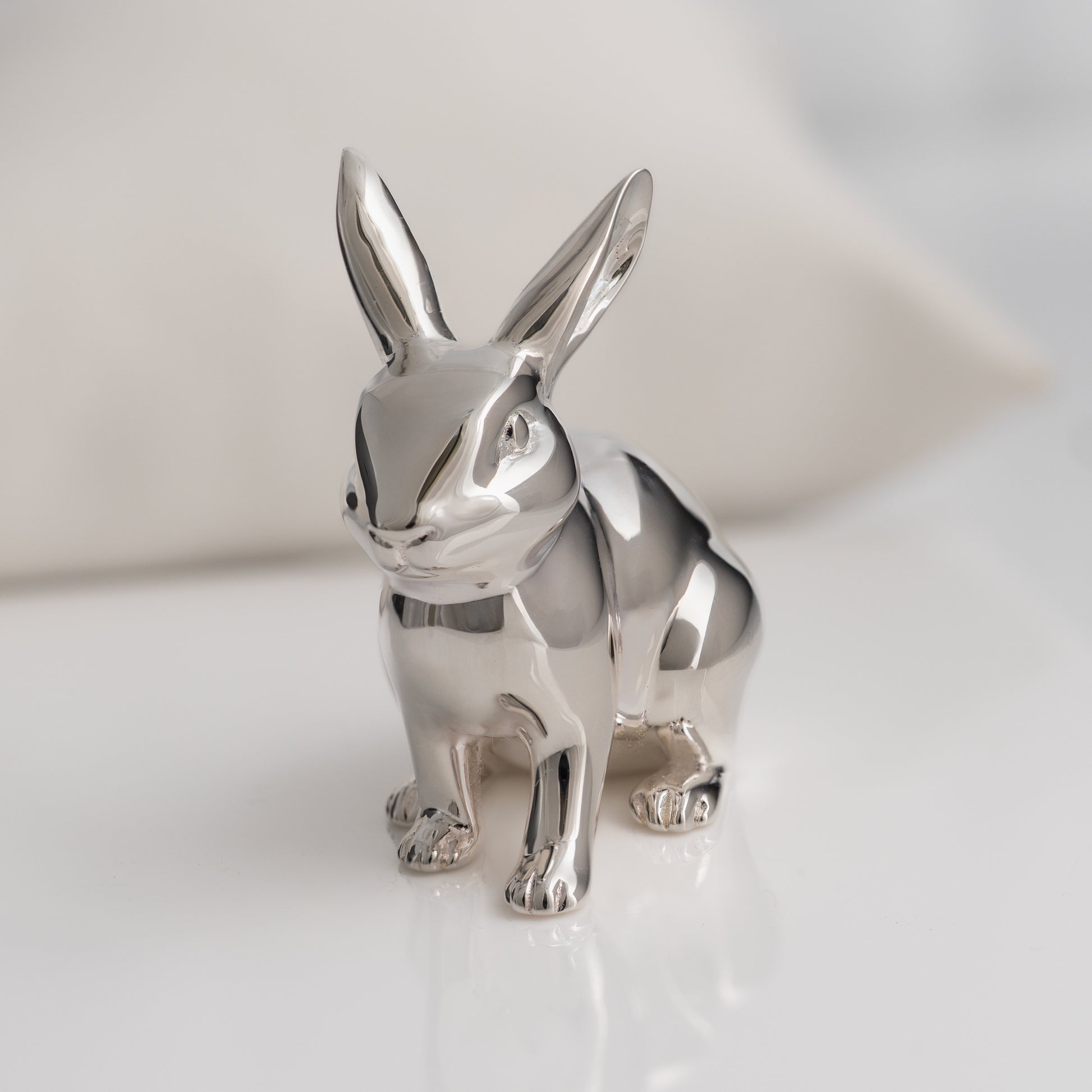 Silver rabbit figurine on a white background