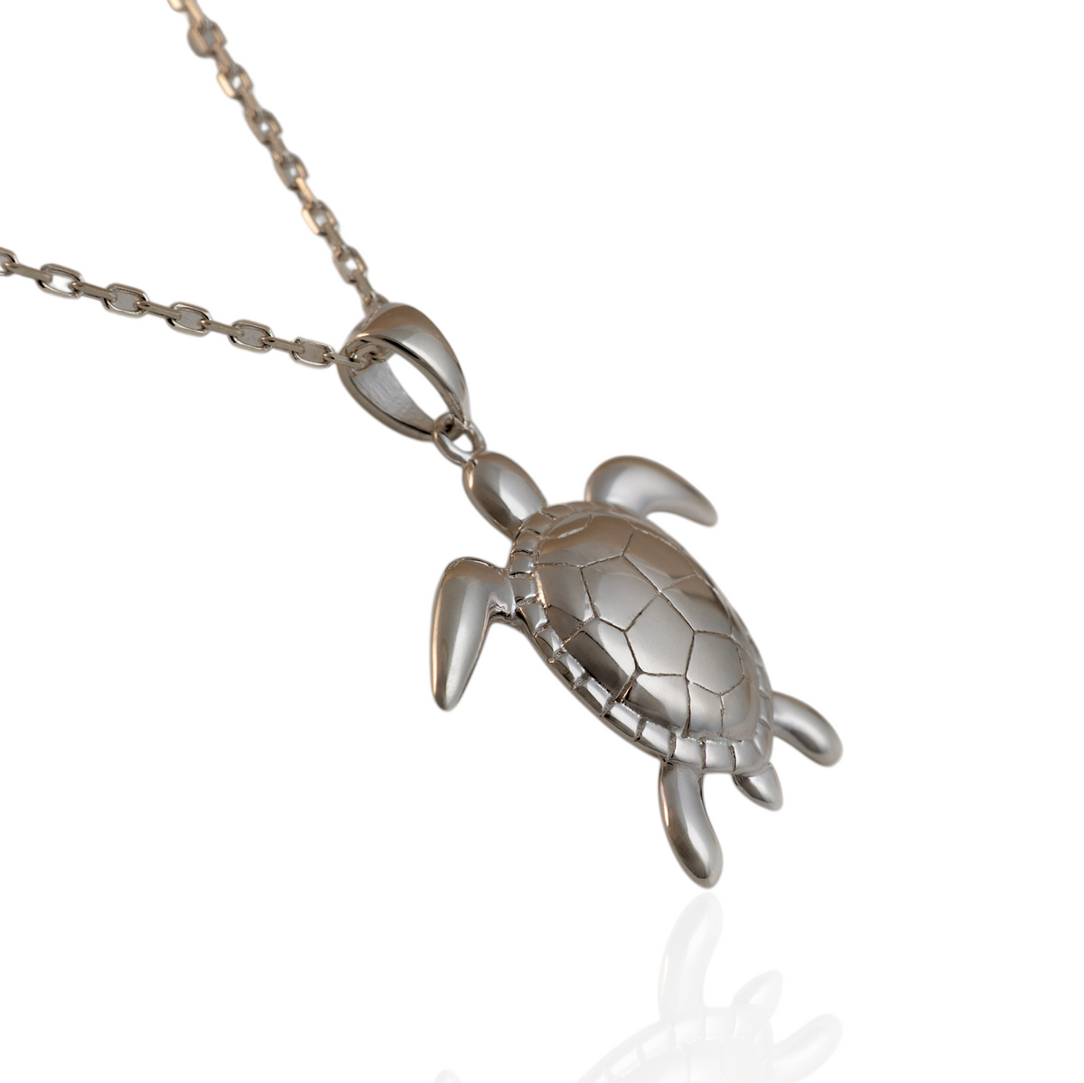 Angled view of a sterling silver sea turtle pendant on a chain, showing the curved shell and flippers