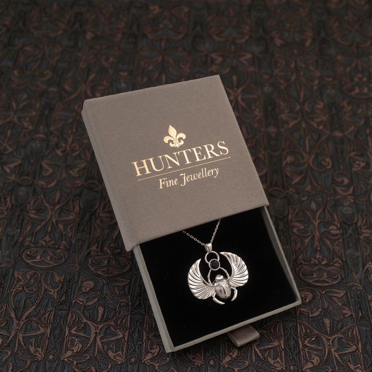 Sterling silver winged scarab pendant with polished black onyx in a HUNTERS Fine Jewellery presentation box.