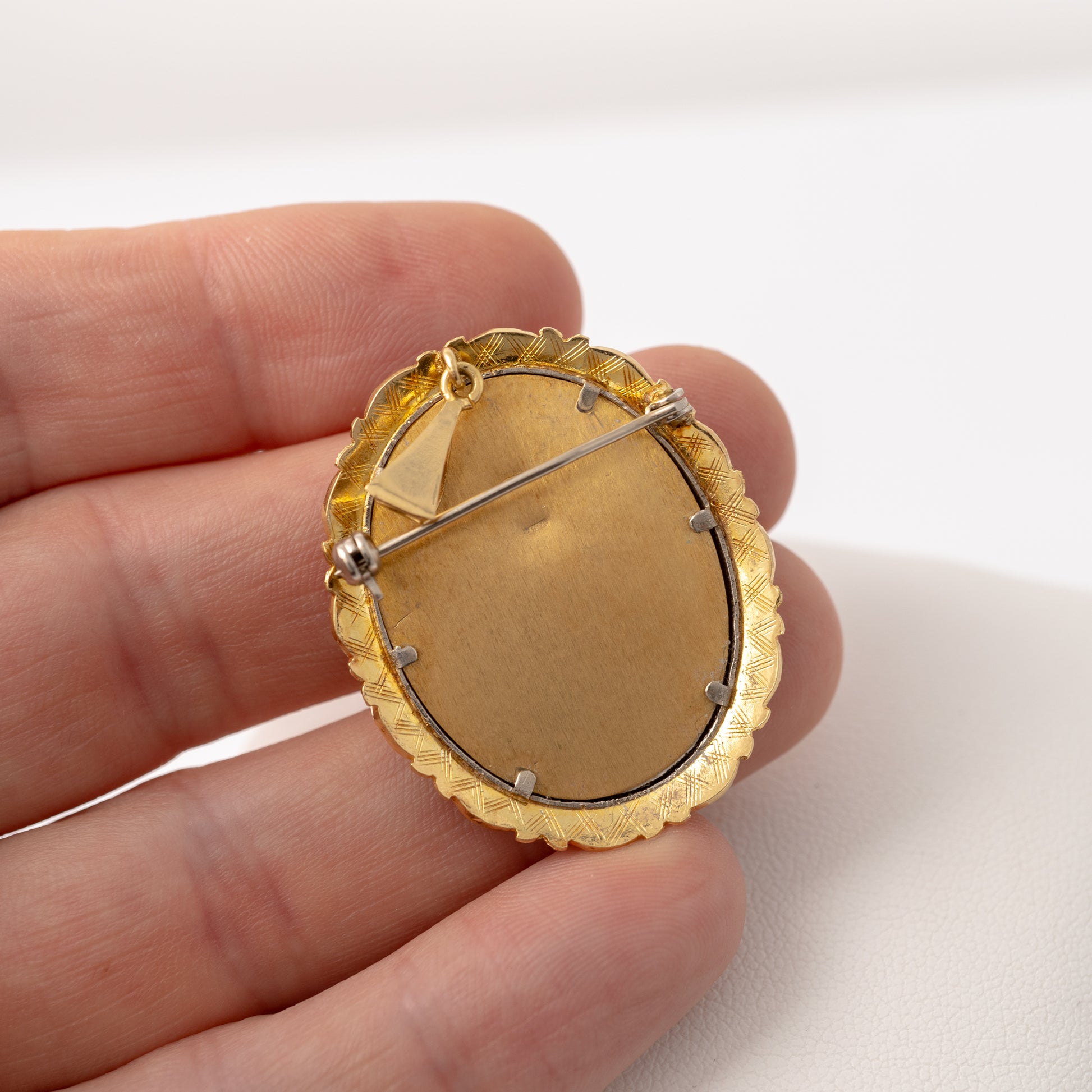 Back view of vintage gold picture pendant brooch showing brushed gold finish and hallmarks