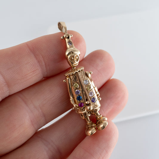 gold clown necklace pendant with colourful gems in hand
