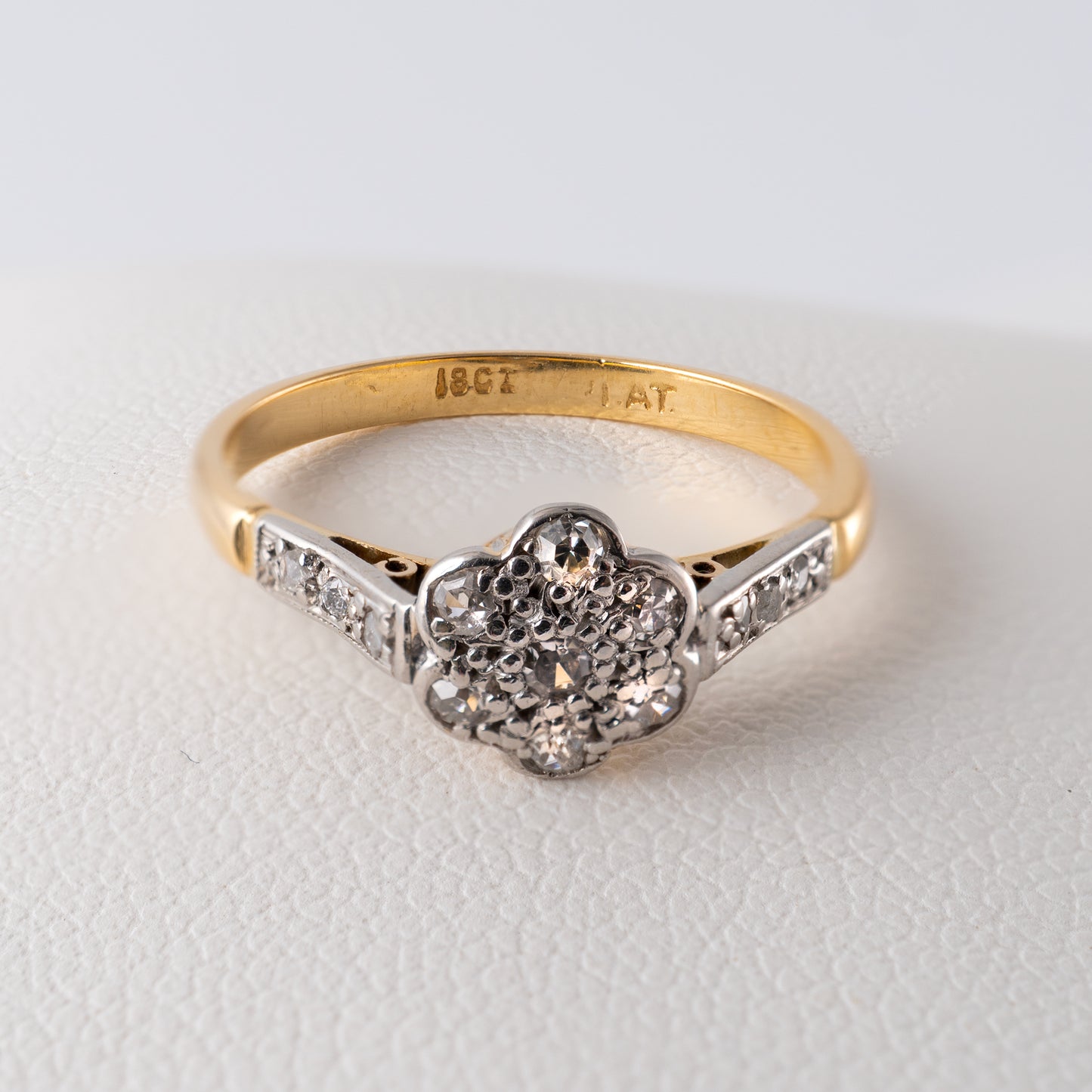 Close-up of the ‘18CT PLAT’ hallmark on a vintage diamond daisy ring in 18ct gold and platinum – Hunters Fine Jewellery.