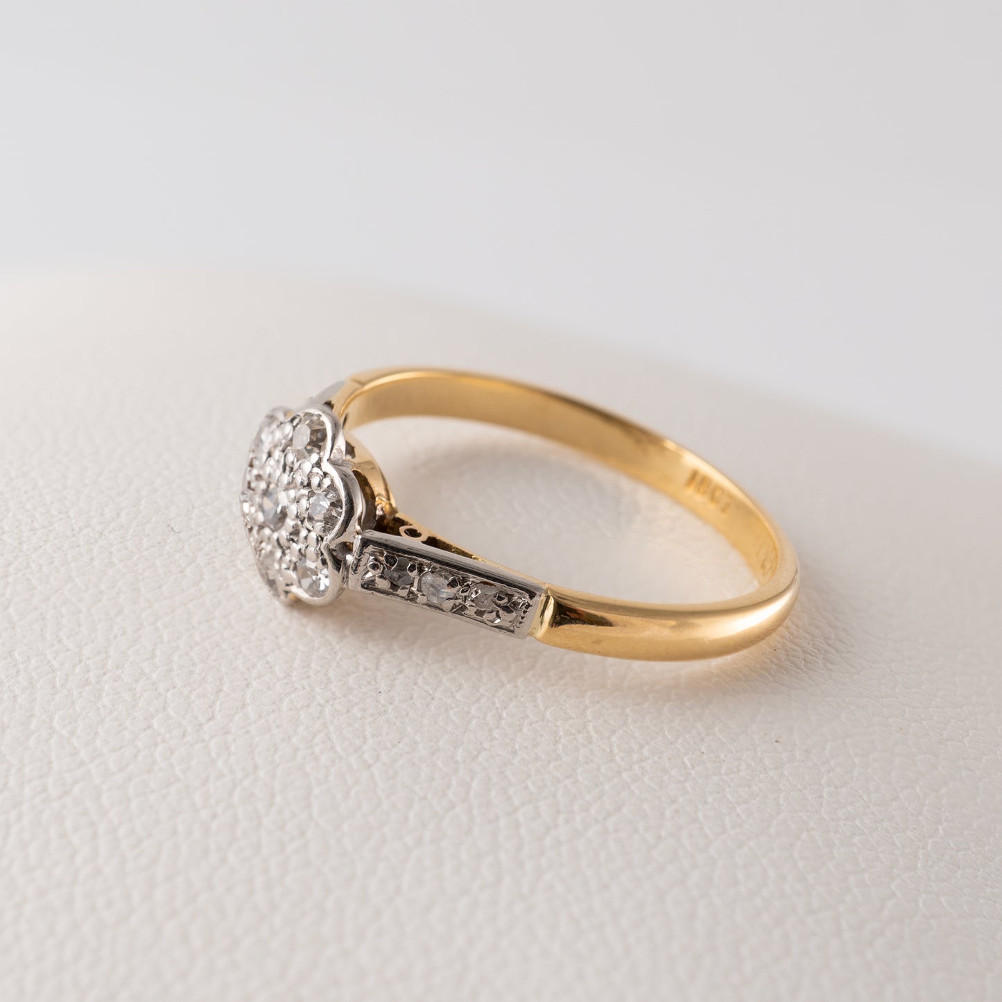 Side angle of a vintage diamond daisy ring in 18ct gold with a platinum setting – Hunters Fine Jewellery.