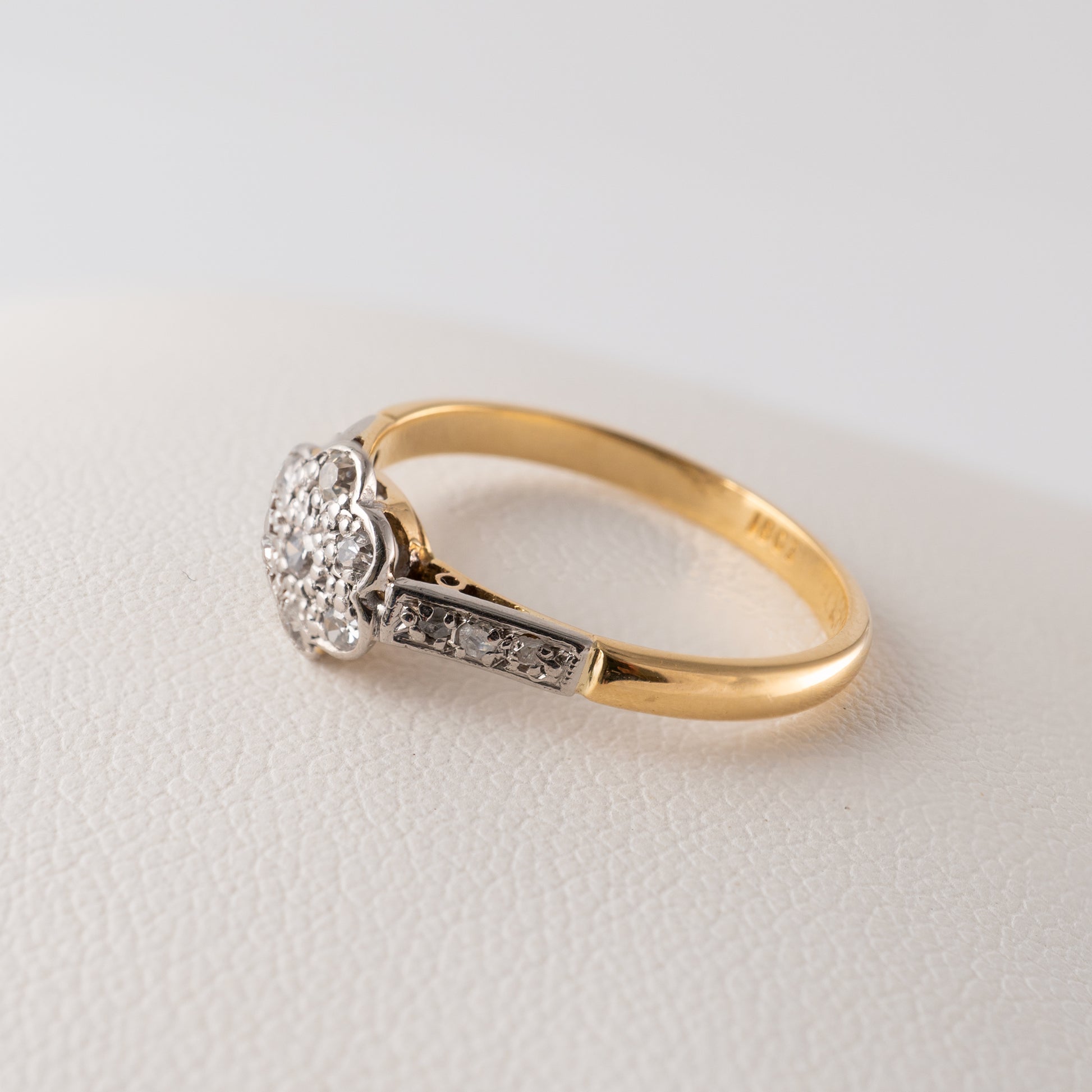 Side angle of a vintage diamond daisy ring in 18ct gold with a platinum setting – Hunters Fine Jewellery.