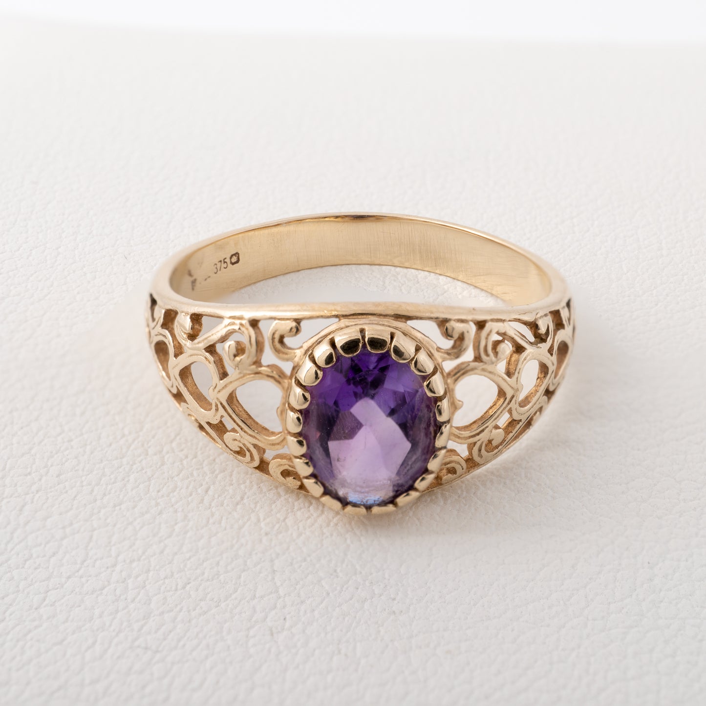 Close-up of vintage 9ct gold amethyst ring featuring an intricate openwork heart pattern